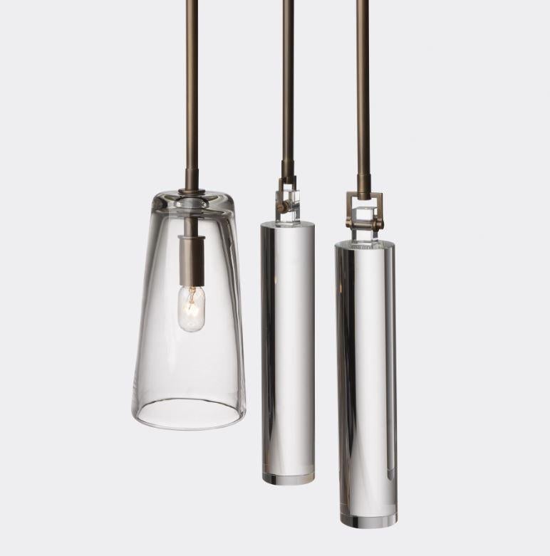 The Clock Pendant is a three-piece fixture comprising a glass pendant and two weights crafted from hand-blown solid crystal in the designer’s studio.