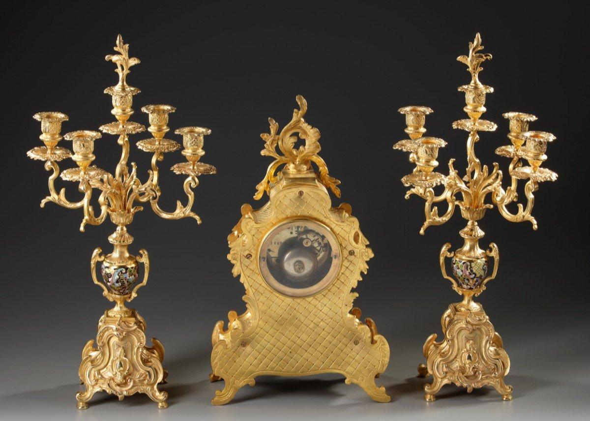 Clock set in gilt and Champleve bronze XIXth century
French champlevé enamel and gilded ormolu clock garniture, each candelabra with five branches, enamel decoration and scrolling feet. Louis XV style. Late 19th century.
In a perfect