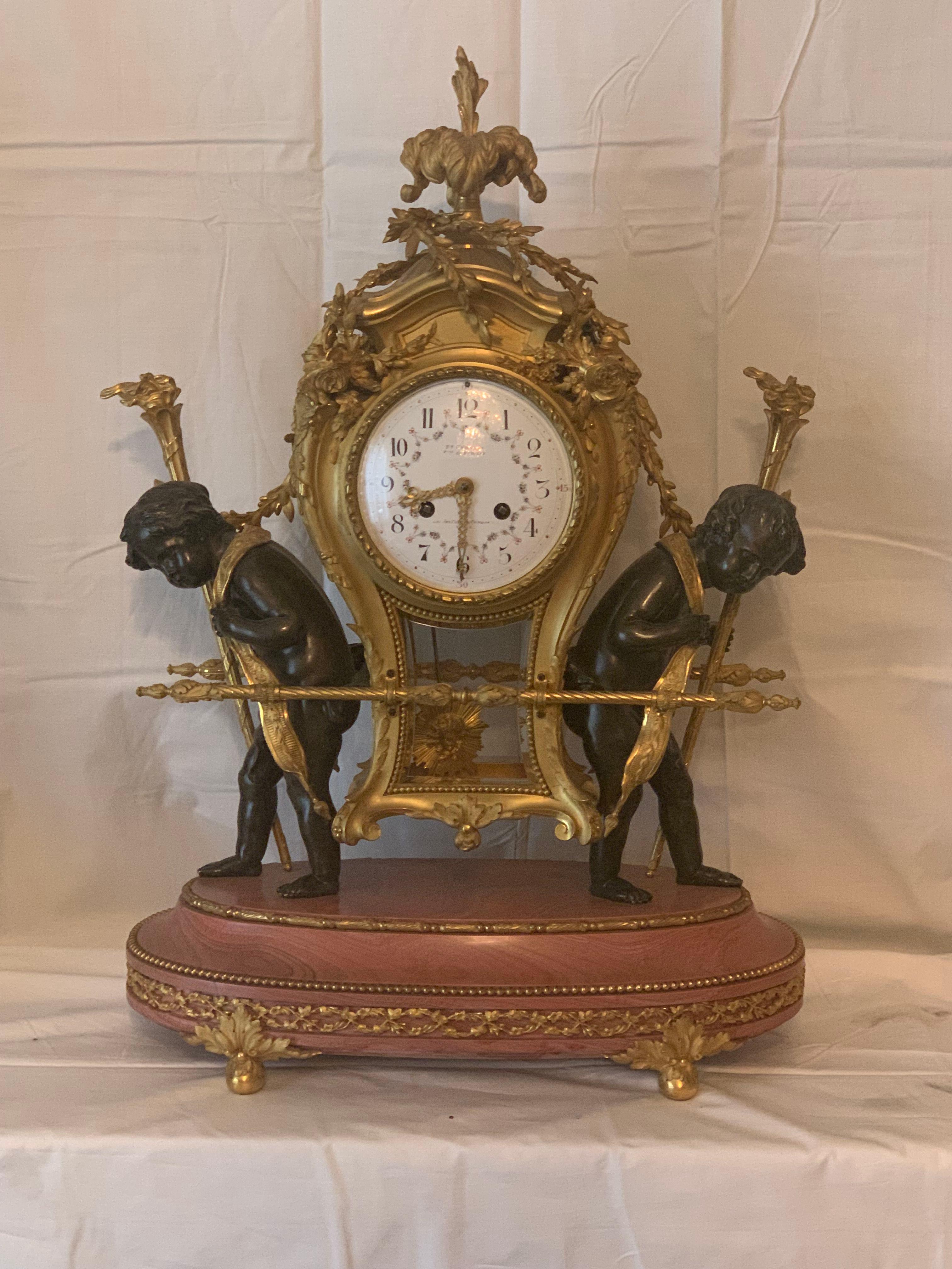 Horloge unique en marbre rose et bronze, pièce d'art décorative
L'horloge est conçue à l'image d'une chaise à porteurs du 18e siècle, c'est-à-dire une chaise couverte dans laquelle s'asseyait un membre de l'élite sociale et qui était portée par