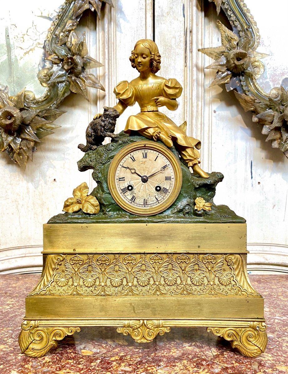 Uhr aus vergoldeter und patinierter Bronze mit einem sitzenden jungen Mädchen, das eine Katze streichelt. Qualitätsarbeit mit schöner Vergoldung und zwei Patinas; eine für die Katze und eine für den Felsen. Romantisches Thema um 1830. Uhr