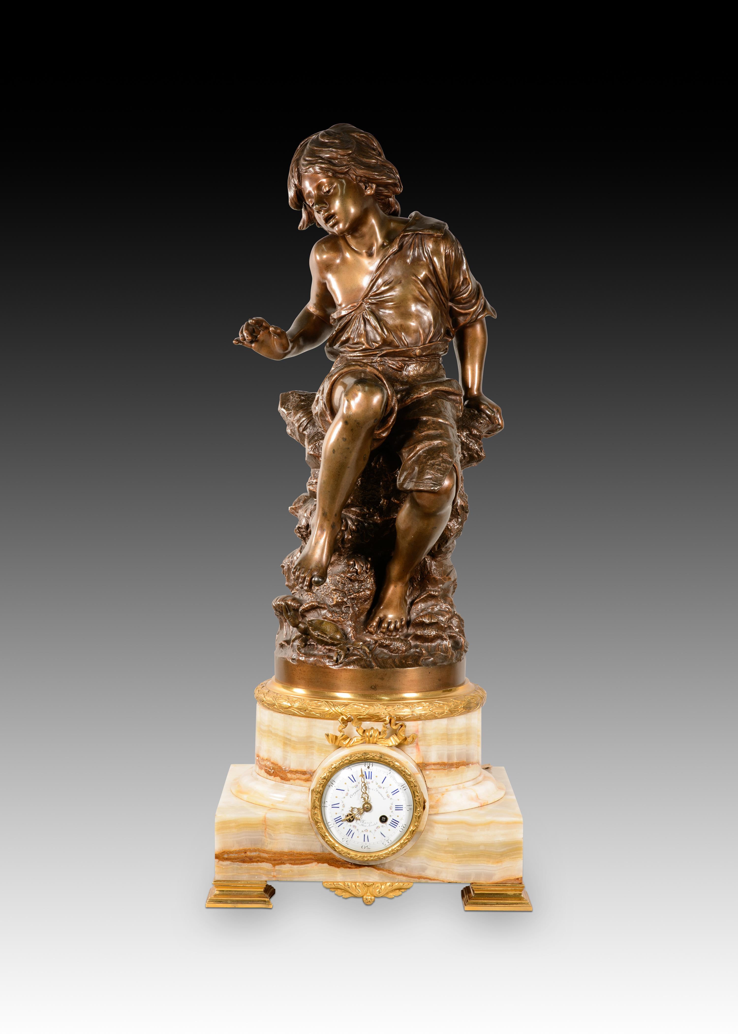 Reloj con escultura. Bronce, piedra. Coupier Fila y Provart, París, Francia, finales del siglo XIX. 
Escultura de bronce que representa a un niño sentado en una formación rocosa, levantando un pie descalzo justo por encima de un cangrejo que levanta