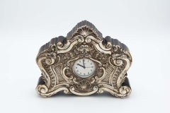 Clock with wooden structure and high reliefs in silver