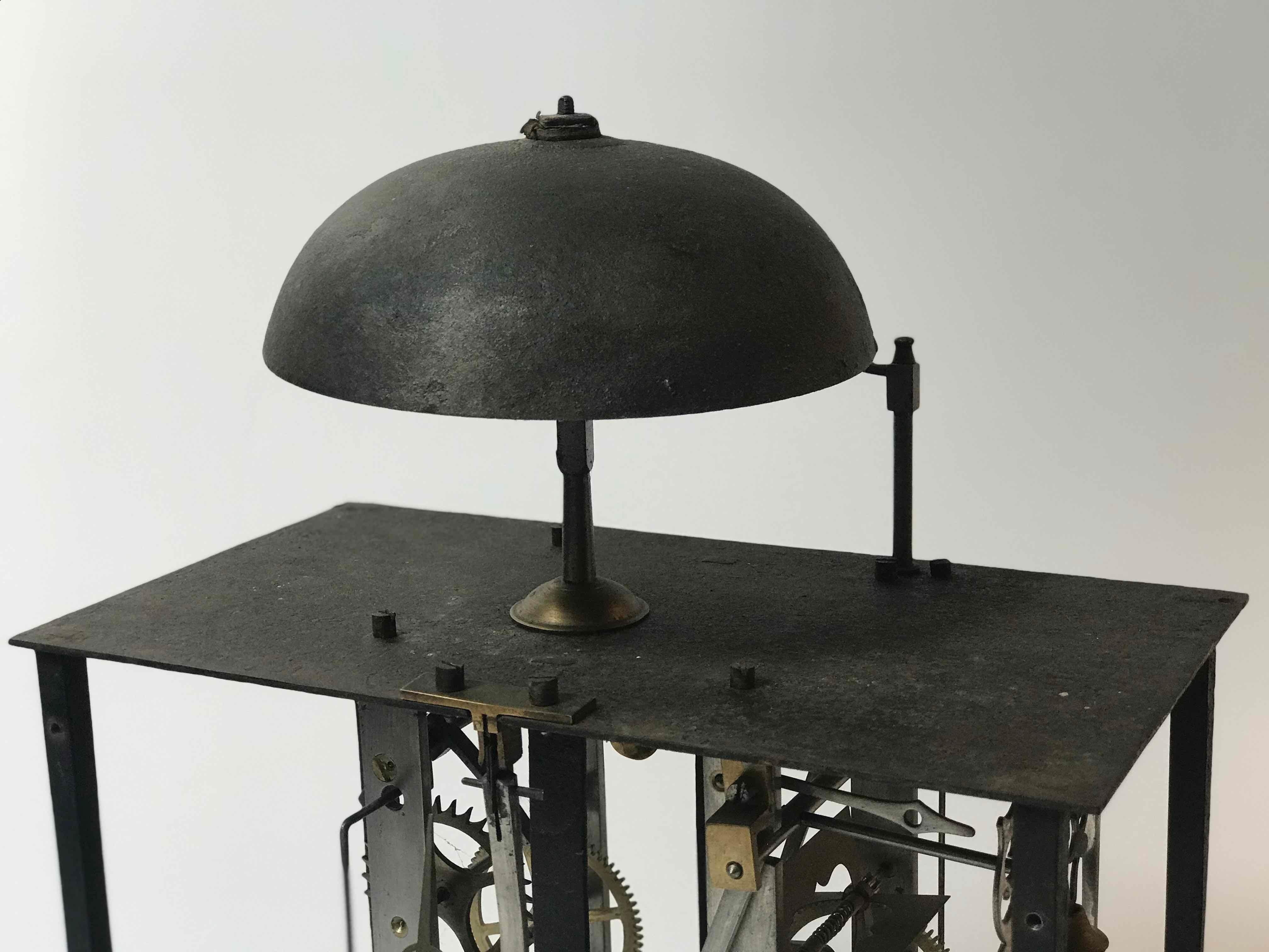 19th-century French clockworks mounted on stand. A unique sculptural piece, this longcase clock has been stripped of its exterior surfacing to reveal the complex operations within. Mounted on a black metal stand, the piece has a gritty, industrial