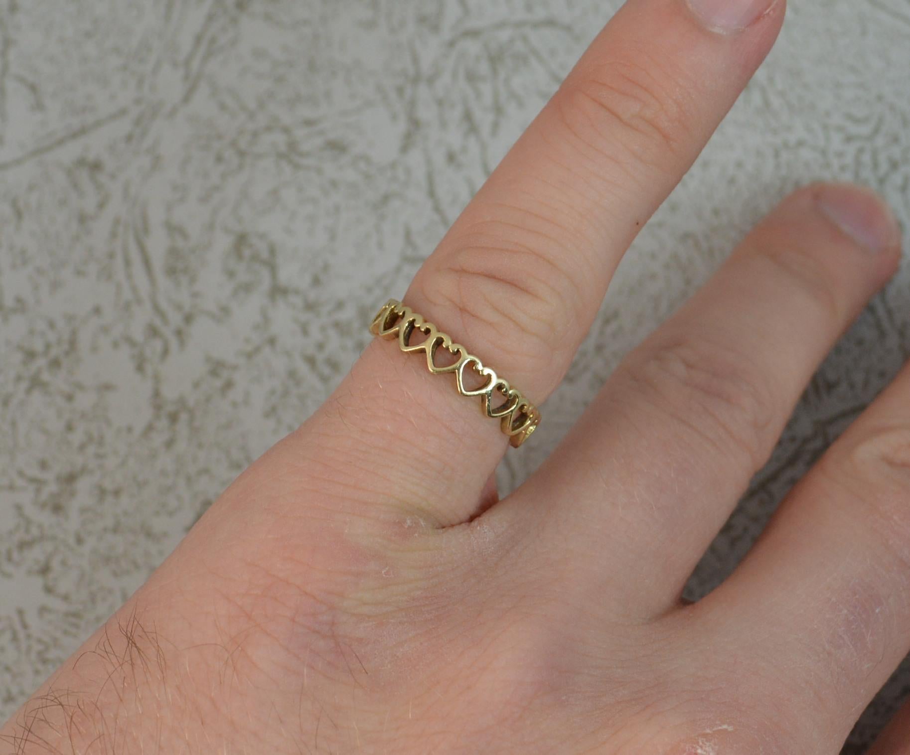 A fantastic CLOGAU designer ring.
Solid 9 carat yellow gold example.
Full eternity band ring, pierced heart design.
3.8mm wide band throughout.

Condition ; Crisp design. Solid piece. Issue free. Cleaned. Crisp design.
Please view photographs though