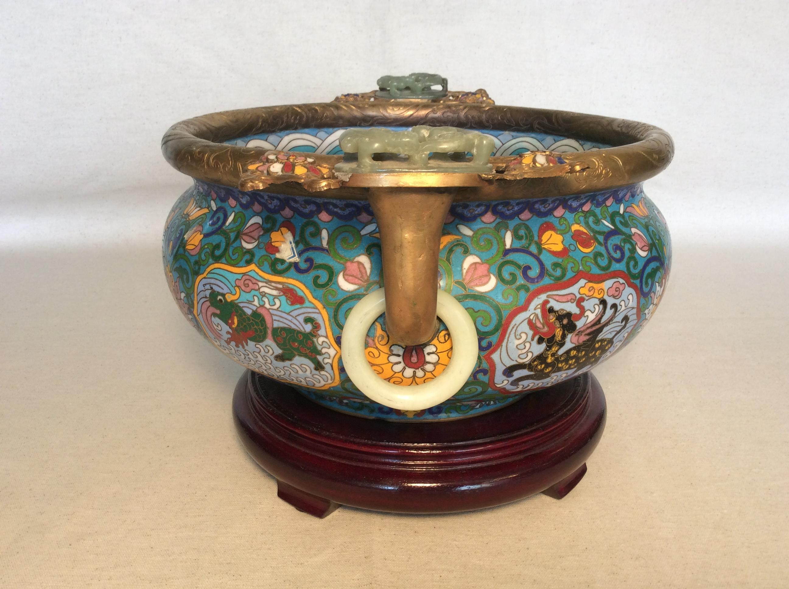 Antique Cloisonné Bowl featuring hand painted dragons inside and out, adorned with jade on the handles.
Chinese parcel gilt, cloisonné censer, mounted with a pair of Qing dynasty, pale celadon nephrite, high relief, double qilong plaques, with