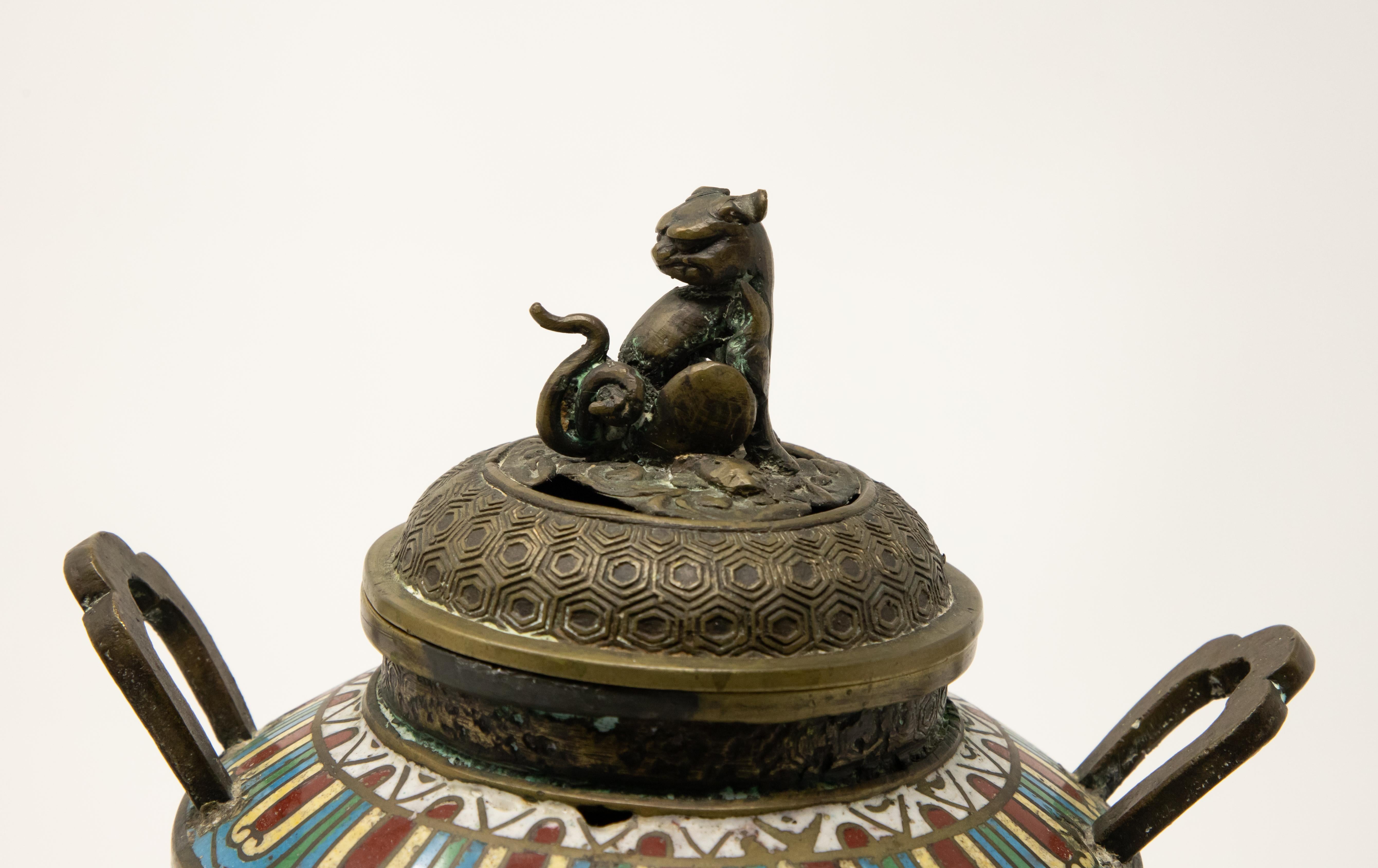 Offering this intriguing Japanese cloisonné bronze censer. Standing on three spiral legs that rise and are joined to the body with lion’s heads. The underside is marked and has a geometric pattern inscribed. From there the rest of the bronze body is