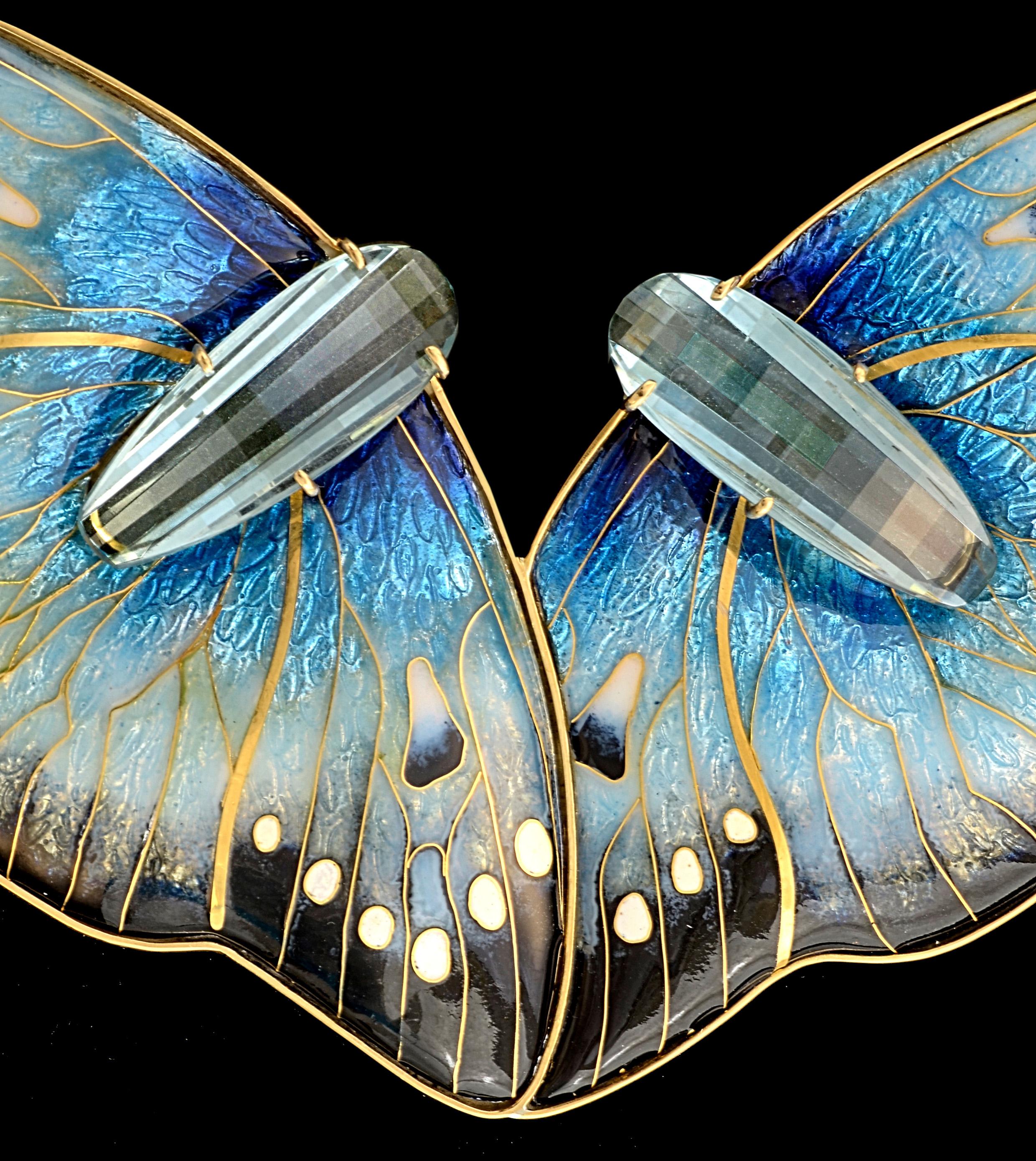 This absolutely unique cloisonné enamel necklace named 
On The Wing is in 24 & 22 karat yellow gold with fine & sterling silver. It won the prestigious international Saul Bell Award in 2016. It is enhanced with two faceted blue quartz stones of
