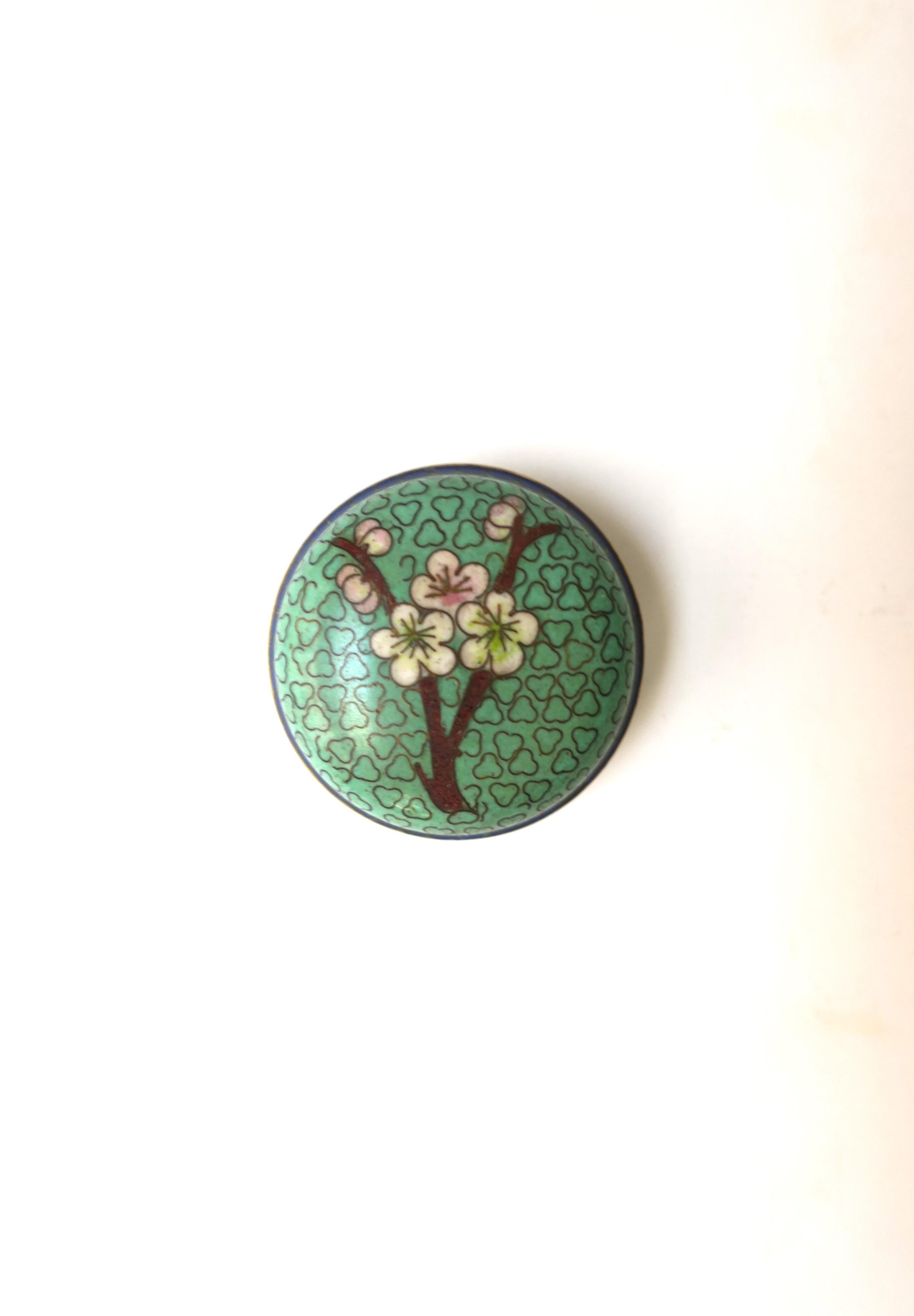 A beautiful small cloisonne box made of colorful enamel and brass, with flower design on lid, in the Chinoiserie style, circa mid-20th century. A convenient piece to hold a ring or earrings (demonstrated holding a cocktail ring, and earrings.) A