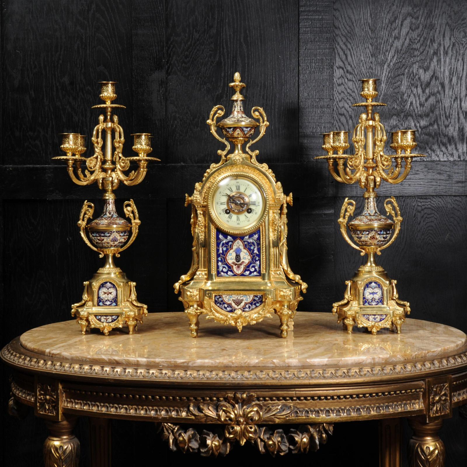 A rare and stunning original antique French clock set by A.D. Mougin. It is beautifully modelled in ormolu (finely gilded bronze) and mounted with exquisite cloisonné or champlevé enamel work. It is in the classical style of Louis XVI with floral