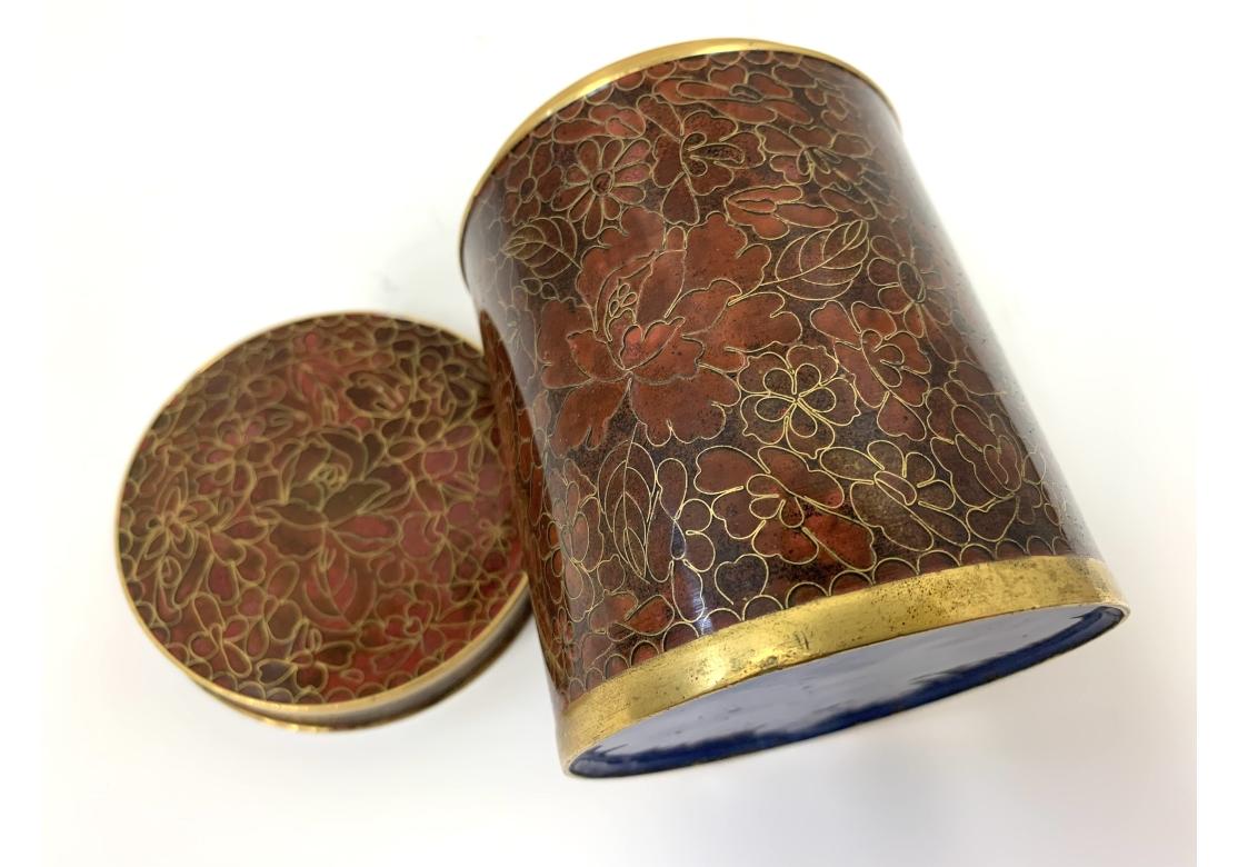 Cloisonne cylindrical jar with matched lid, exposed brass trim with blue enamel interior and on verso.
Dimensions: 3 1/8