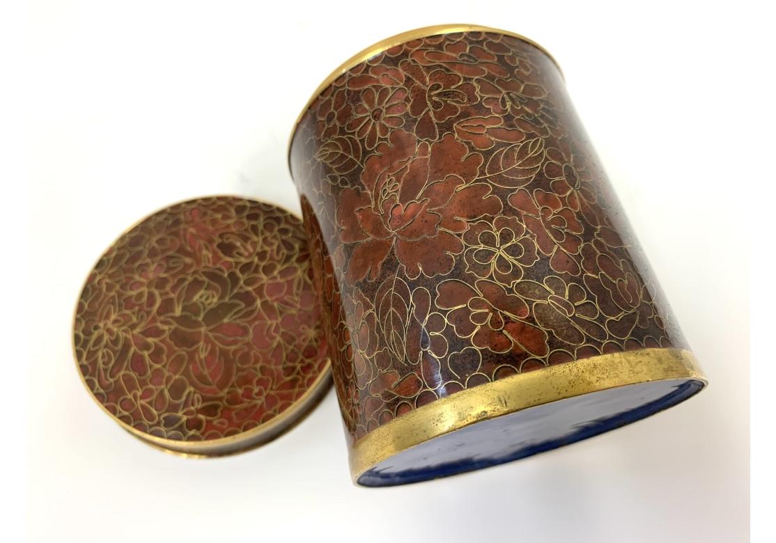 Vaso cilindrico in cloisonne con coperchio abbinato, finiture in ottone a vista con interno in smalto blu e sul verso.
Dimensioni: 3 1/8