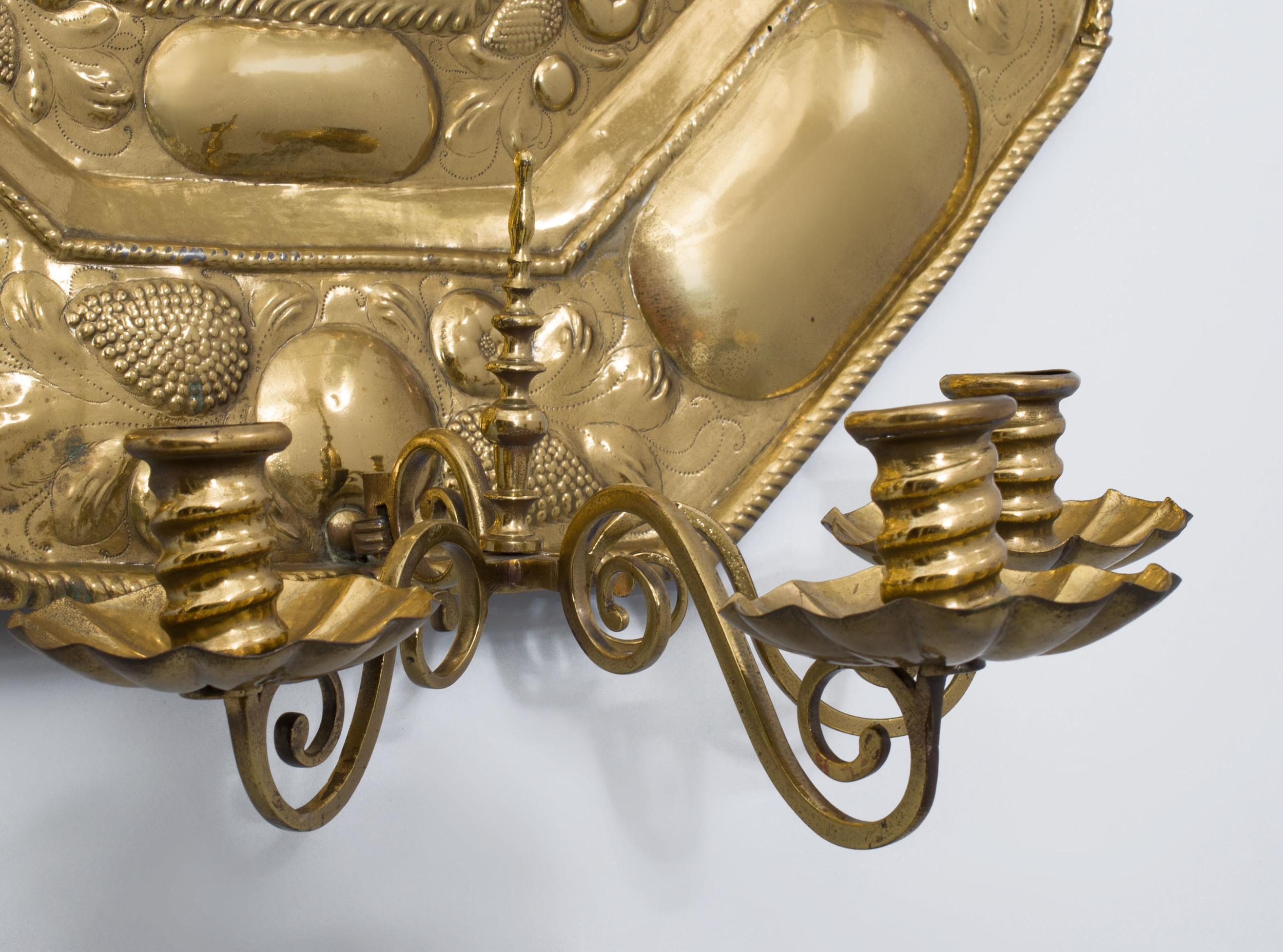 Close pair of Dutch baroque style three-light sconces with brass repousse backplates, late 18th-early 19th century.