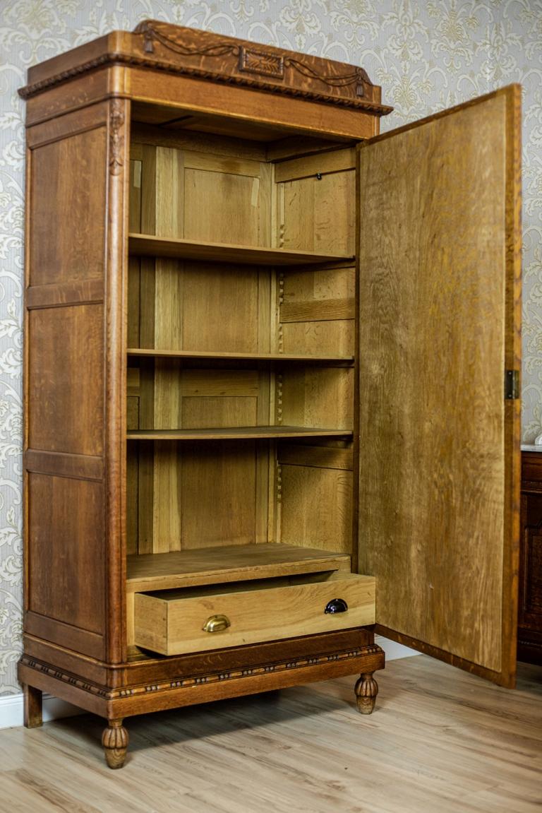 We present you a single-leaf oak closet from the Interwar period.
The inside of this piece of furniture is divided by shelves and a drawer at the basis.
Furthermore, the shelves are attached with serrated stripes. Their height can be