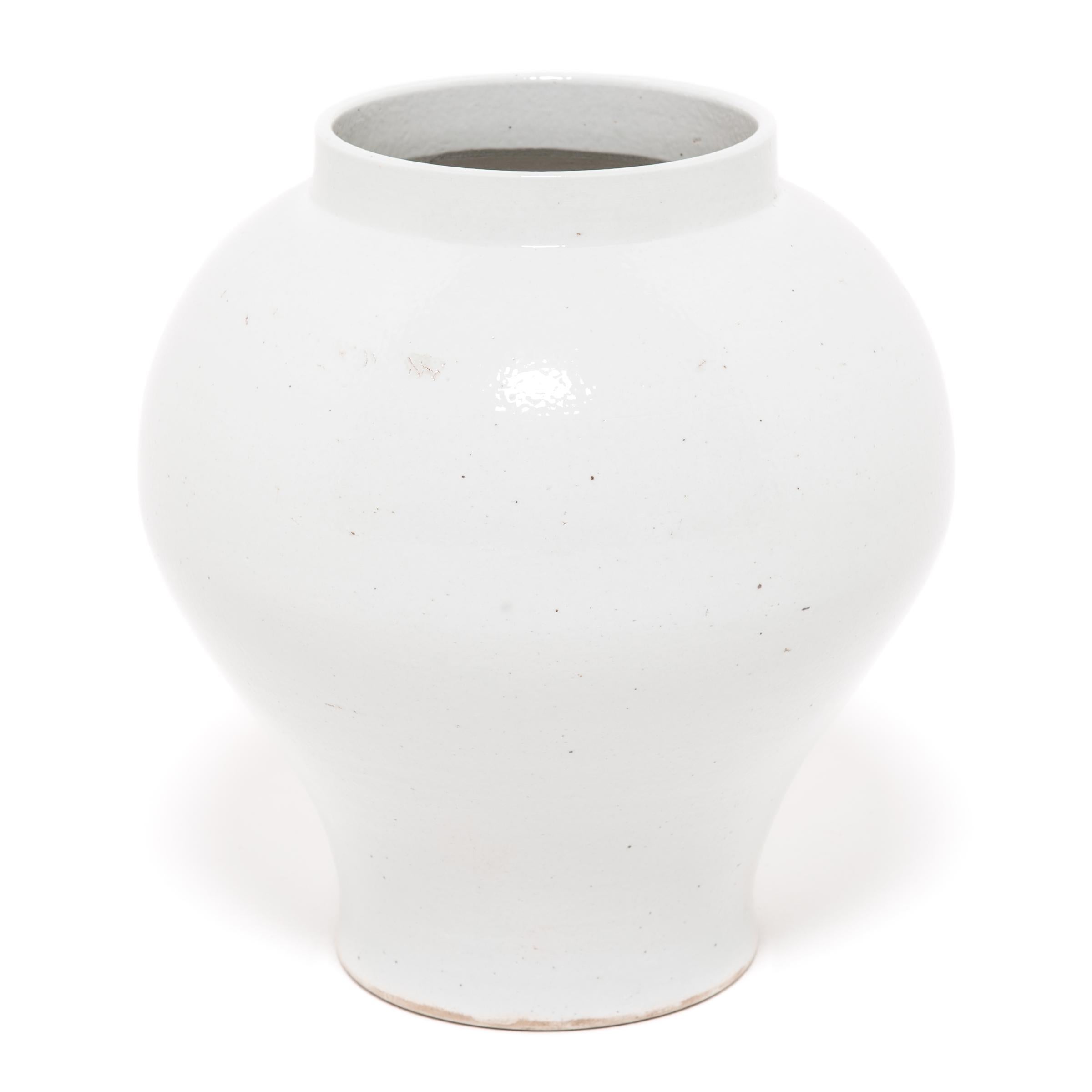 Drawing on a long Chinese tradition of monochrome ceramics, this large porcelain vase is glazed in serene, cloud-inspired white with celadon undertones. Sculpted by artisans in China's Zhejiang province, the vase has an impressive sculptural form