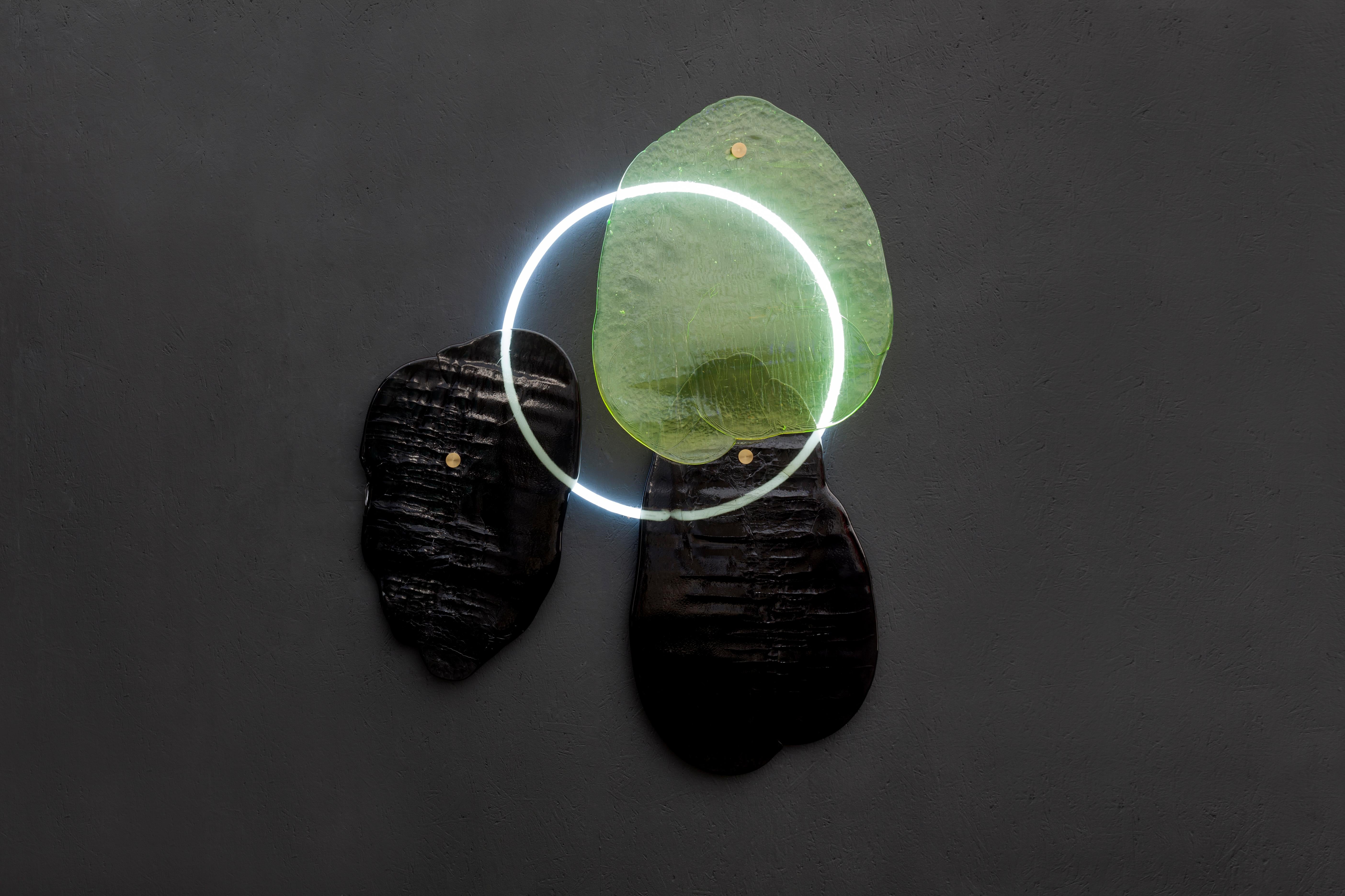 Cloud object by Dechem Studio.
Dimensions: D 8 x W 110 x H 130 cm.
Materials: glass, neon light ring.

Like clouds passing over the sun, translucent glass sheets diffuse the light of a neon tube in this wall object. The amorphous glass elements