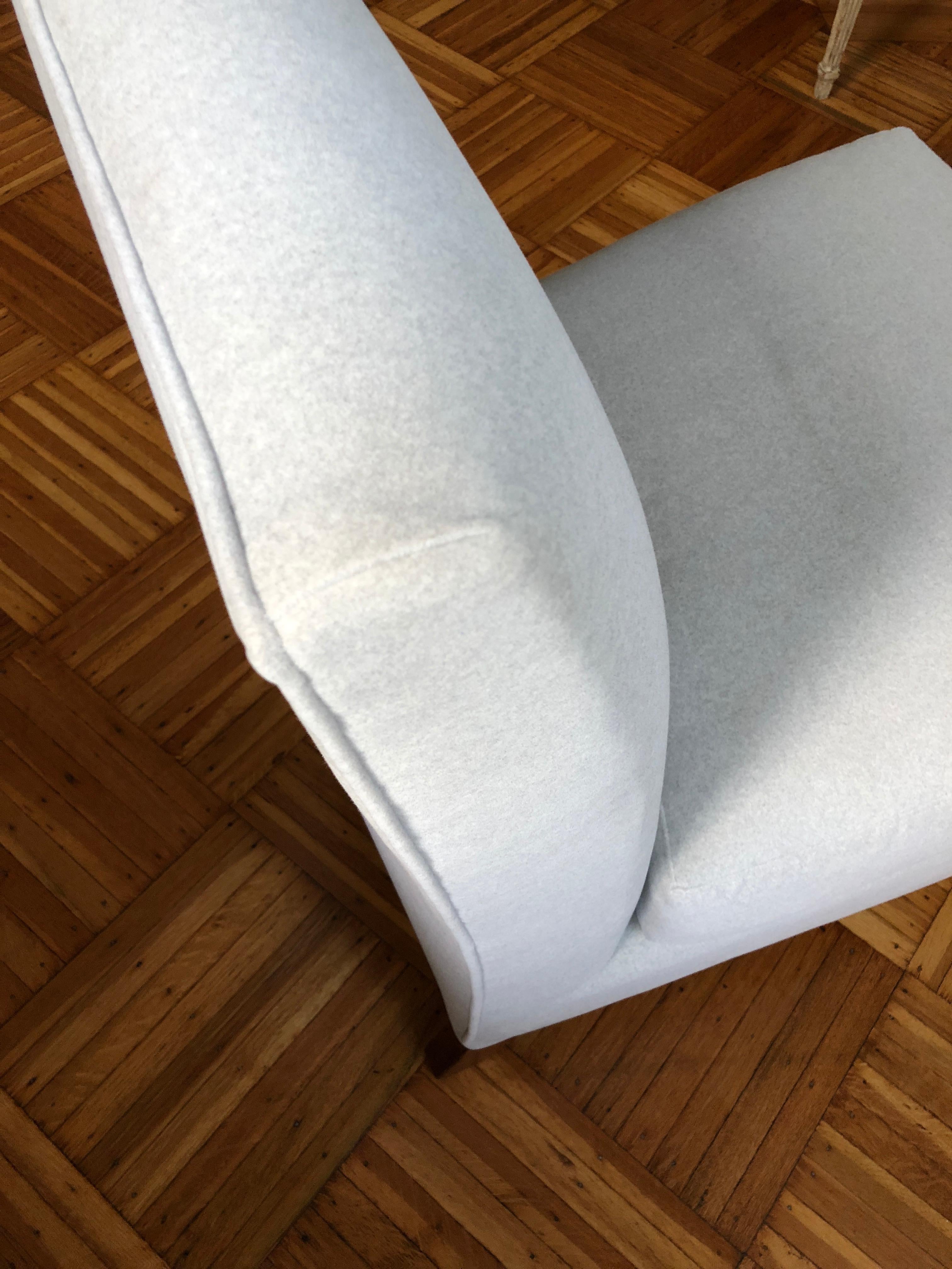Perfectly pitched for supreme comfort, this graceful armless slipper chair adds style and extra seating to any space. High quality, sturdy frame has been restored and reupholstered in pale silver cotton/poly fabric that looks like wool, and feels