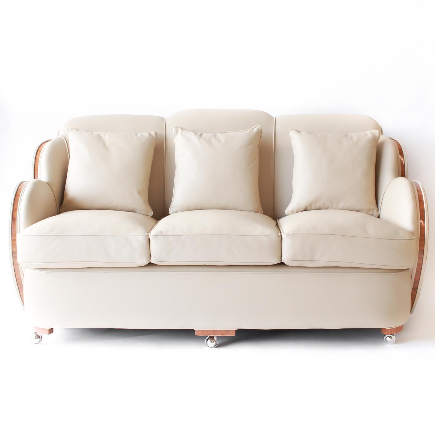 An Art Deco three-piece cloud suite. Three-seat cloud back sofa and two armchairs with straight grain walnut show wood. Upholstered in cream leather and Alcantara suede

Measures: Sofa H 85 cm, W 167 cm, seat H 47 cm, seat D 80 cm
Chairs H 85 cm, W