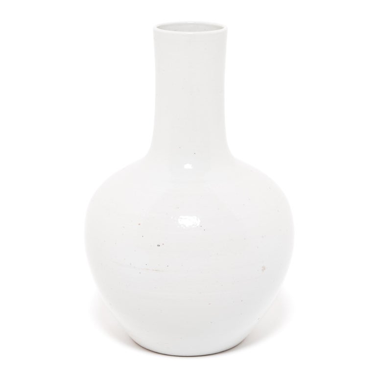 A simple and modern shape defines these bottleneck vases, known as such because of their shorter necks. This charming vase, updates the Classic bottleneck design with a more graphic, modern silhouette. The striking cream-colored glaze nods to the