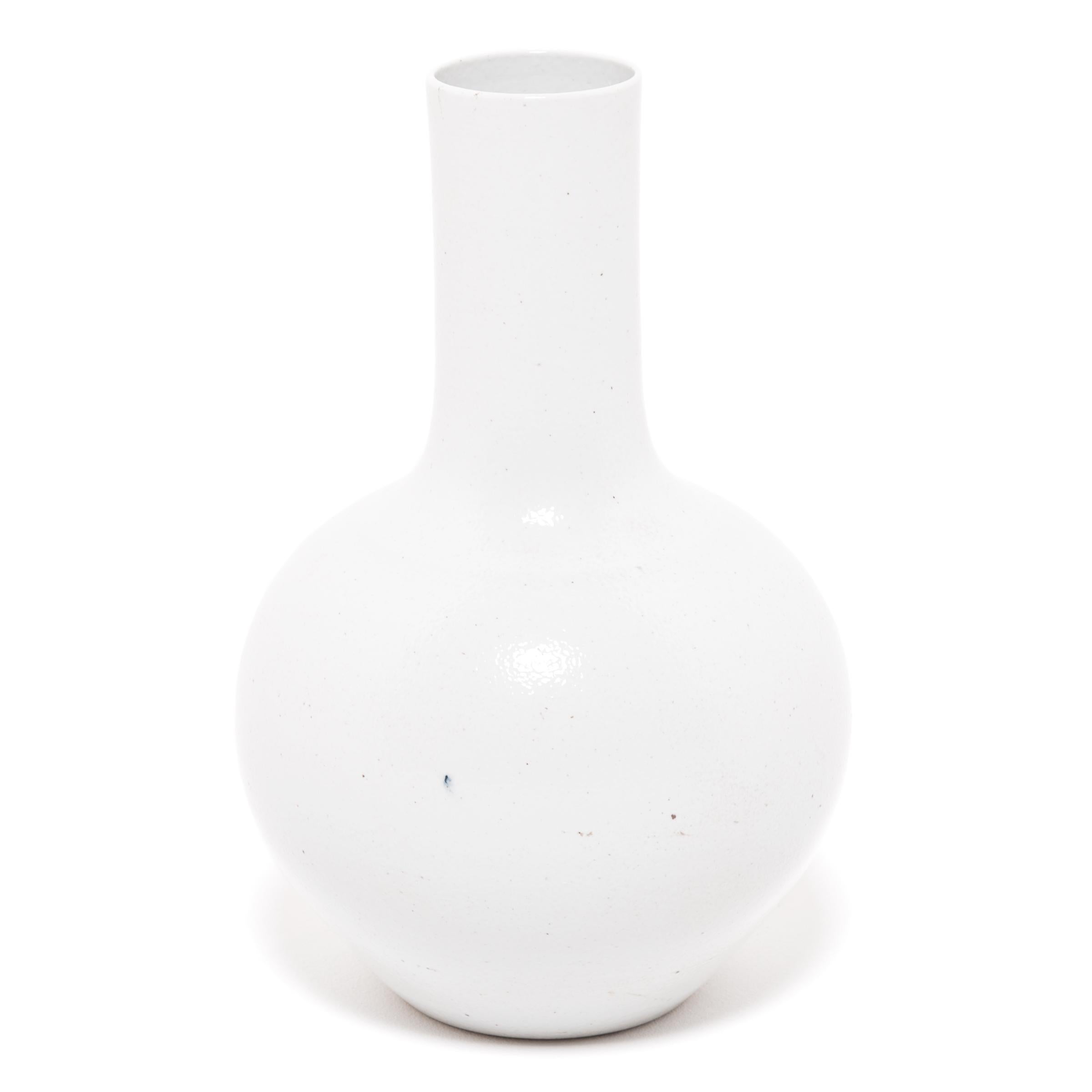 Drawing on a long Chinese tradition of ceramics, this striking long-necked vase is cloaked in an all-over milky white glaze. Sculpted by artisans in China's Zhejiang province, the large vase reinterprets a traditional gooseneck shape known as a