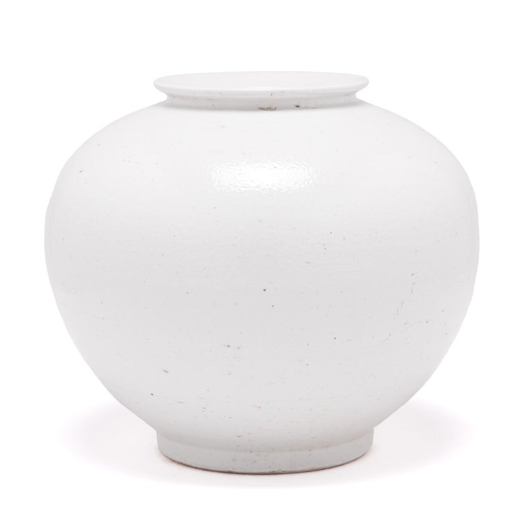 A milky white glaze emphasizes the simple, serene beauty of this contemporary ceramic vase. Refining the traditional onion shape, the round jar has clean lines and an understated sculptural presence.