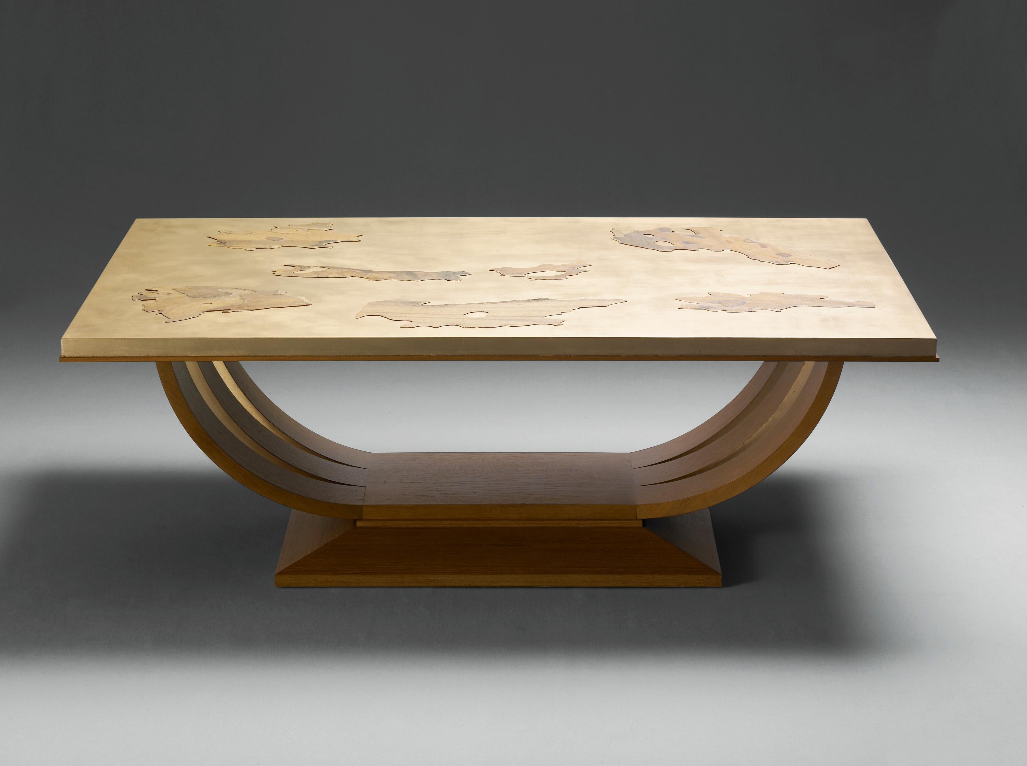 Clouds is a coffee table inspired by a classical style. The top is covered with gold leaf and an inlay made with plane tree bark. The bark was cut into several cloud-shaped pieces that give the table its name. The legs are formed by six semicircular