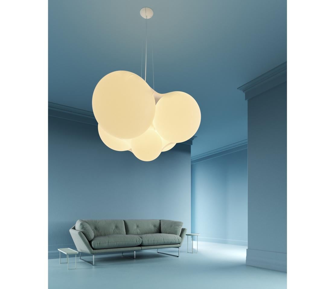 Designed by Dima Loginoff, cloudy is a true luminous sculpture that dominates the space with its presence and diffuses a soft and cozy light.

Five spherical elements of different dimensions wrapped in a semi-transparent elastic fabric, form