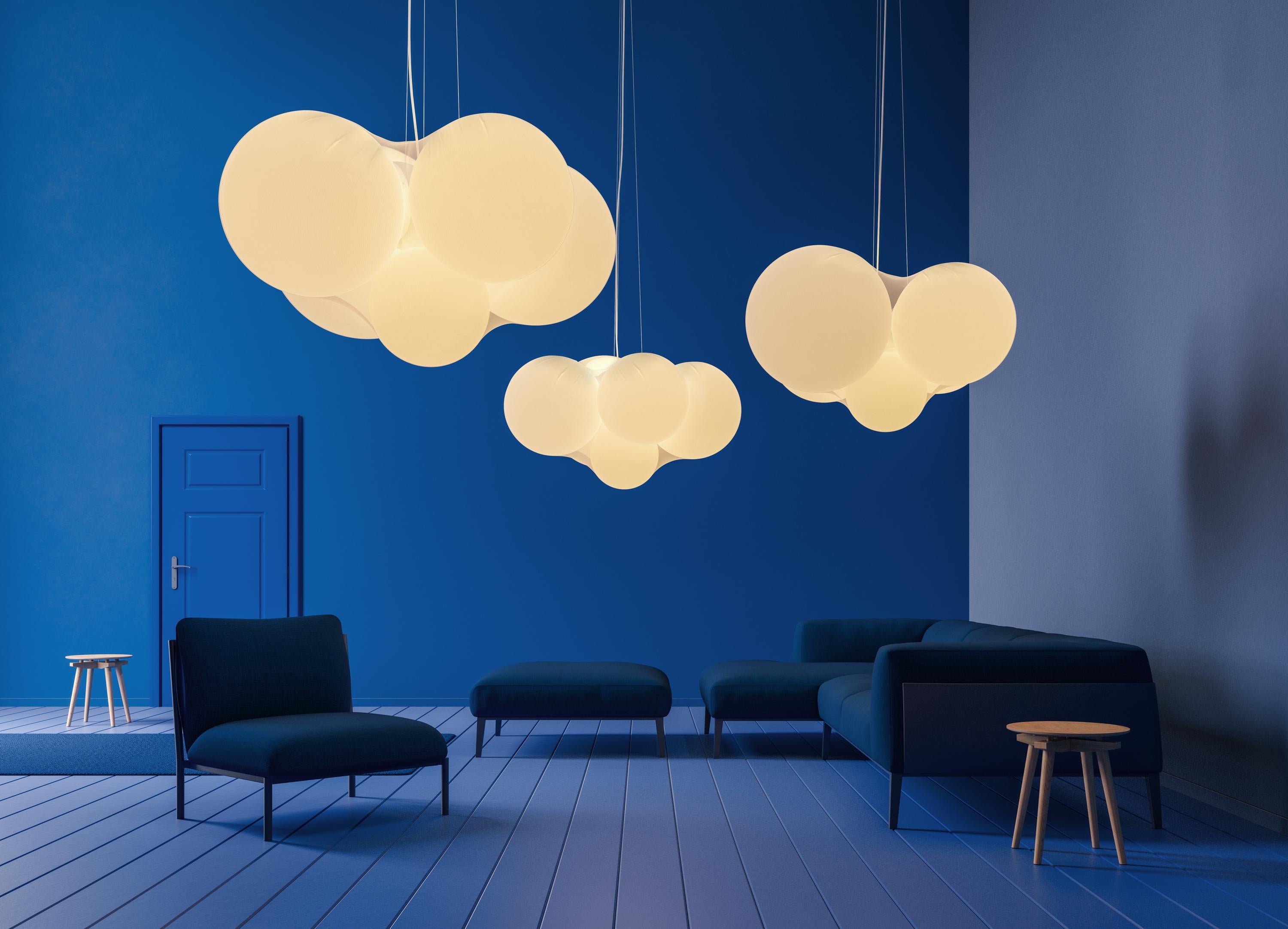 Designed by Dima Loginoff, Cloudy is a true luminous sculpture that dominates the space with its presence and diffuses a soft and cosy light.

Five spherical elements of different dimensions wrapped in a semi-transparent elastic fabric, form