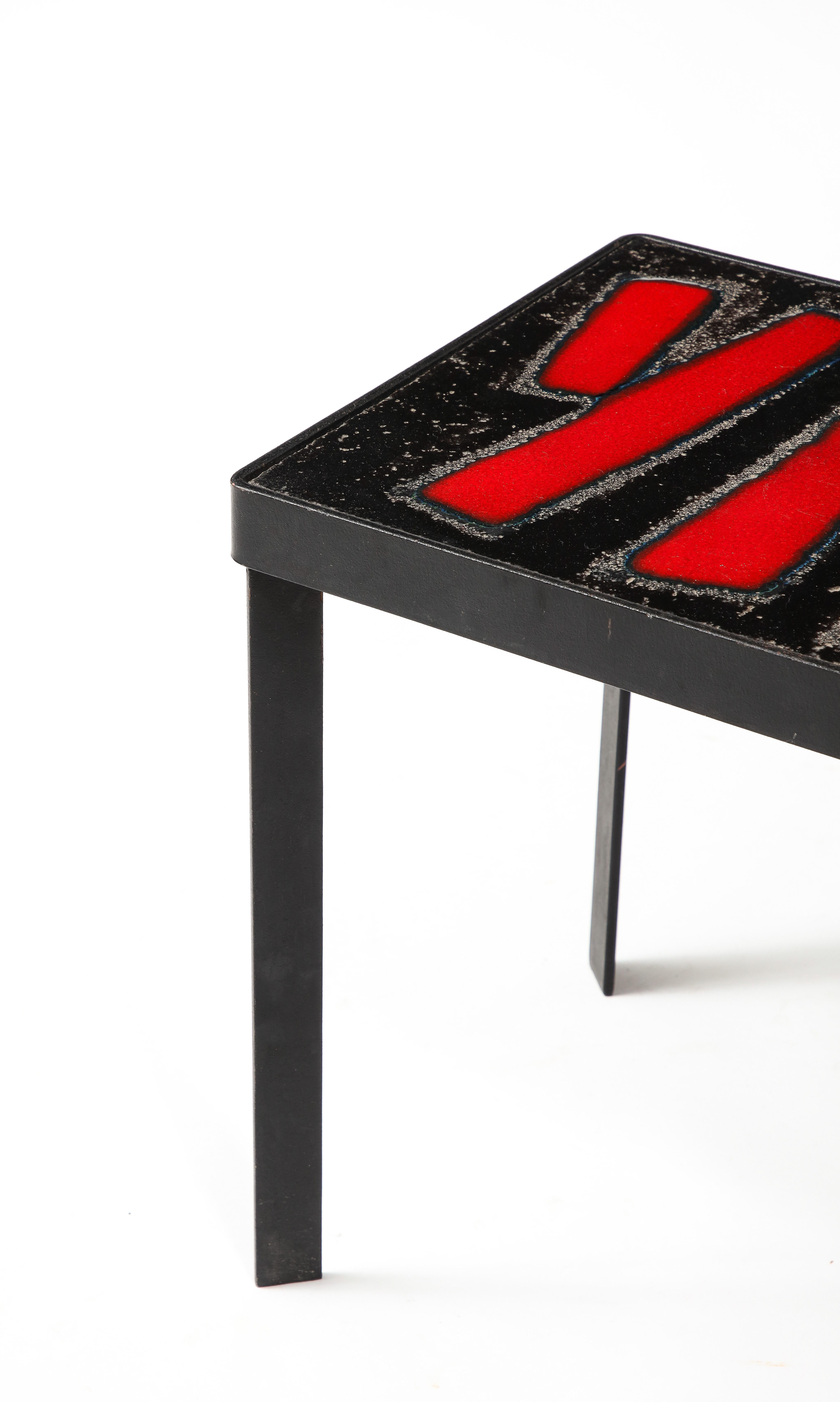 Striking Nesting tables in red enameled lava stone, blackened steel bases with canted legs.