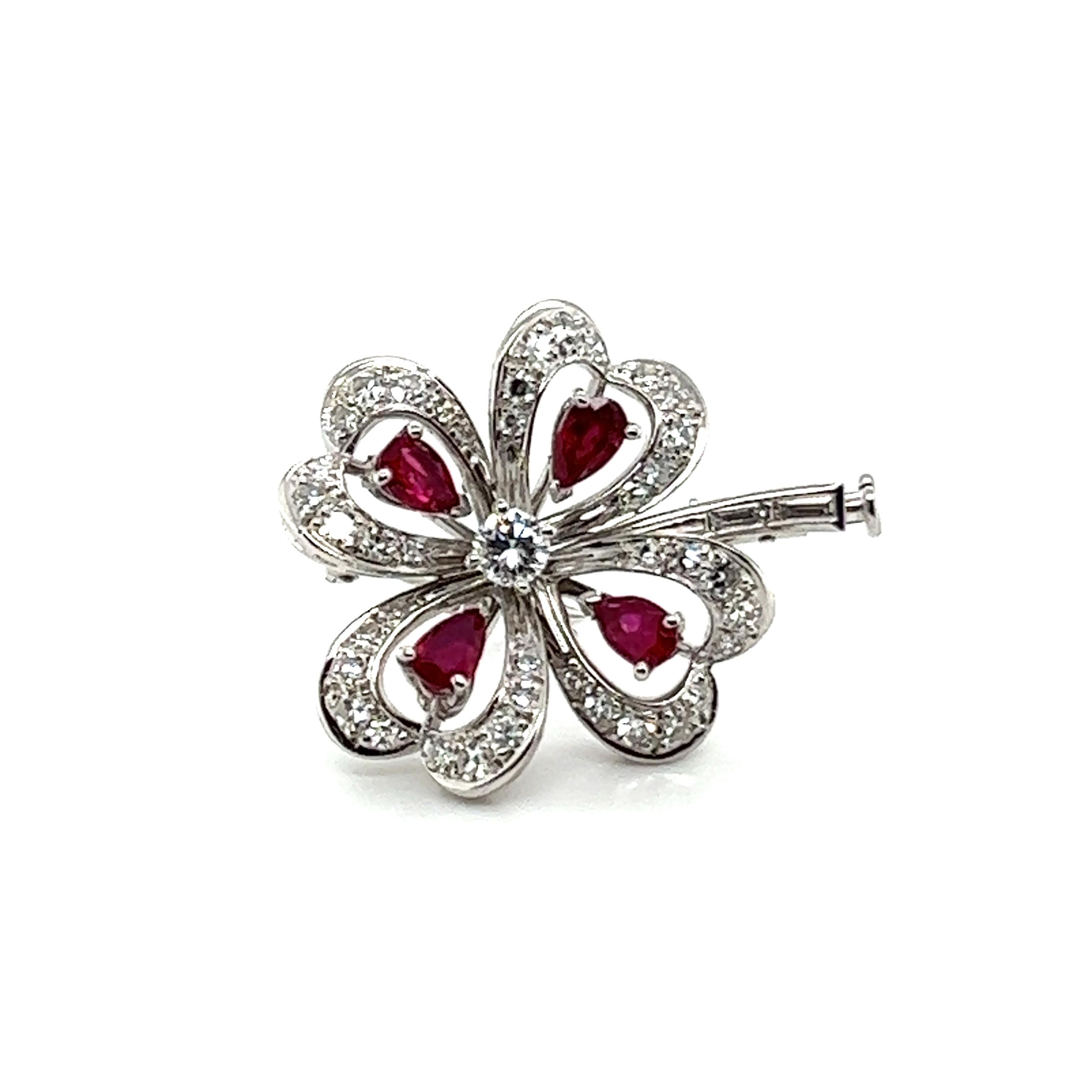 What a fortunate talisman - an exquisite clover brooch with diamonds and rubies from the finest 18 Karat white gold by refined Swiss jeweler Meister. 
 
Each of the four petals of the clover is adorned with four pear-shaped rubies, totaling 1.00