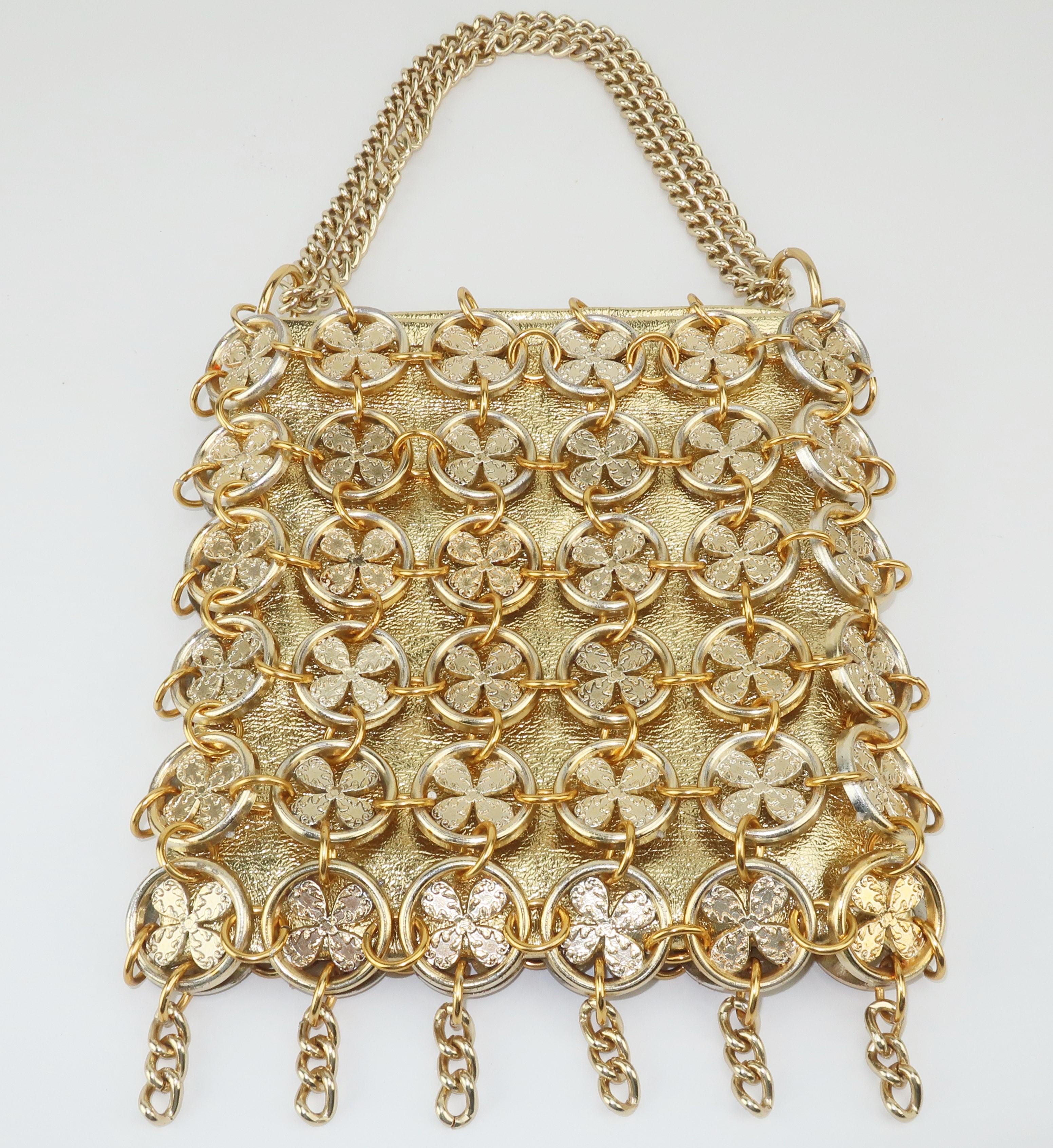 A swinging '60's gold handbag with a fun mix of a chain mail look and a lucky four leaf clover symbol.  Reminiscent of Paco Rabanne's iconic designs from the same era, this bag consists of a gold vinyl body with an overlay of disks and rings