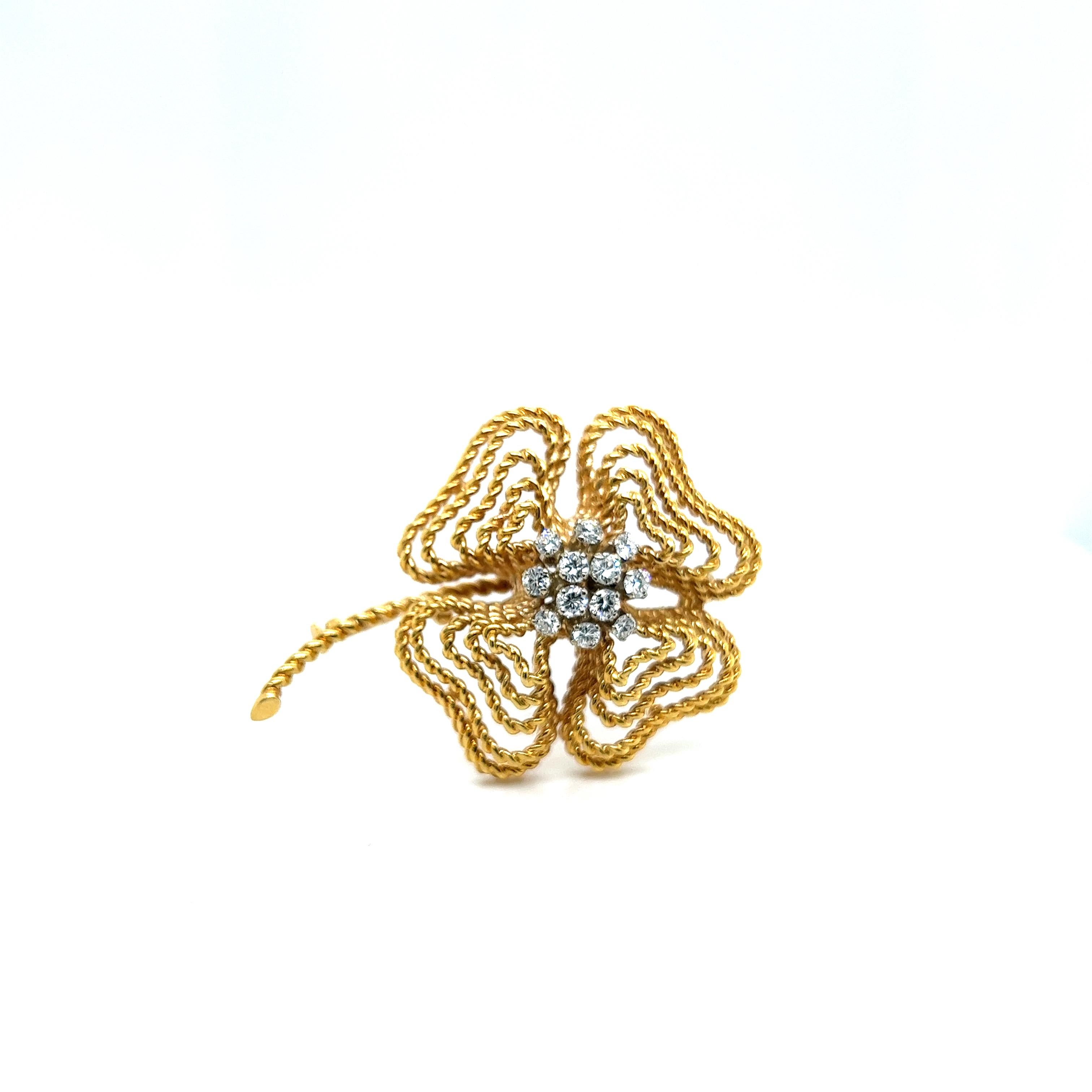 This clover brooch with diamonds in 18 Karat yellow and white gold is a masterpiece of craftsmanship. design of the twisted felsic gold chain gives it texture and sophistication, while the central cluster of 0.72 carat diamonds, framed in white gold