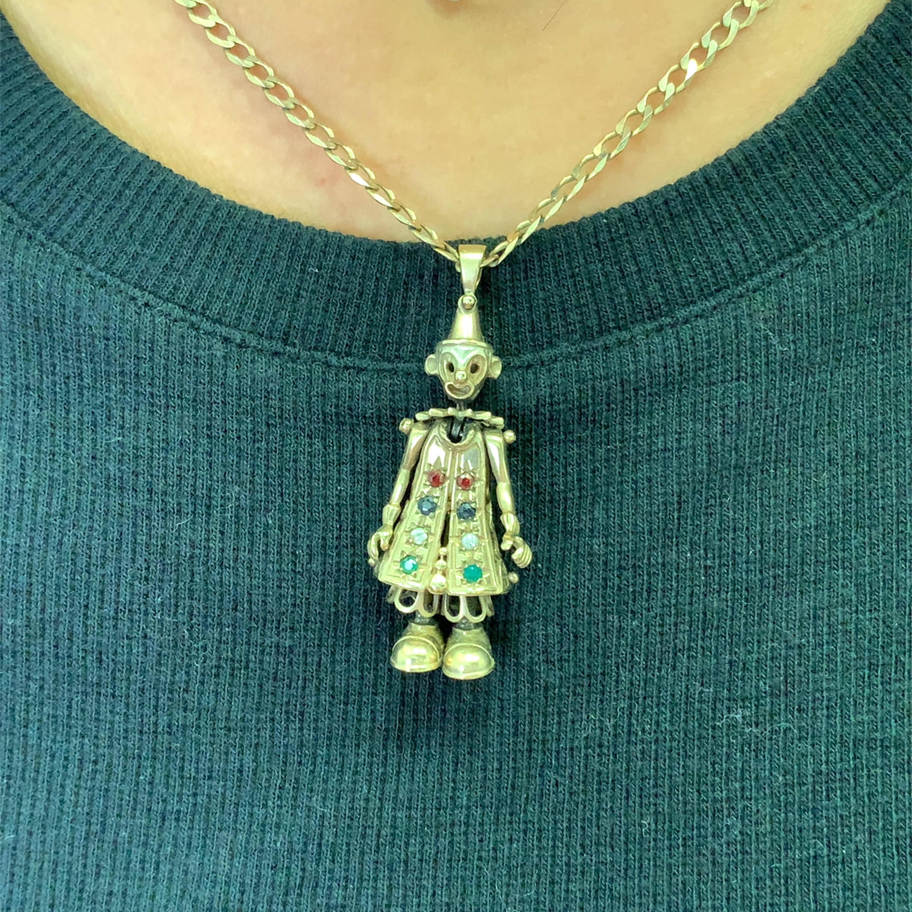 Diese skurrile Halskette mit Charme aus 9 Karat Gold wertet Ihr Ensemble auf. Ein verspielter, beweglicher Vintage-Clown-Anhänger aus Gold ist mit Smaragden im Rundschliff und Saphiren verziert und verleiht ihm einen Hauch von unbeschwerter