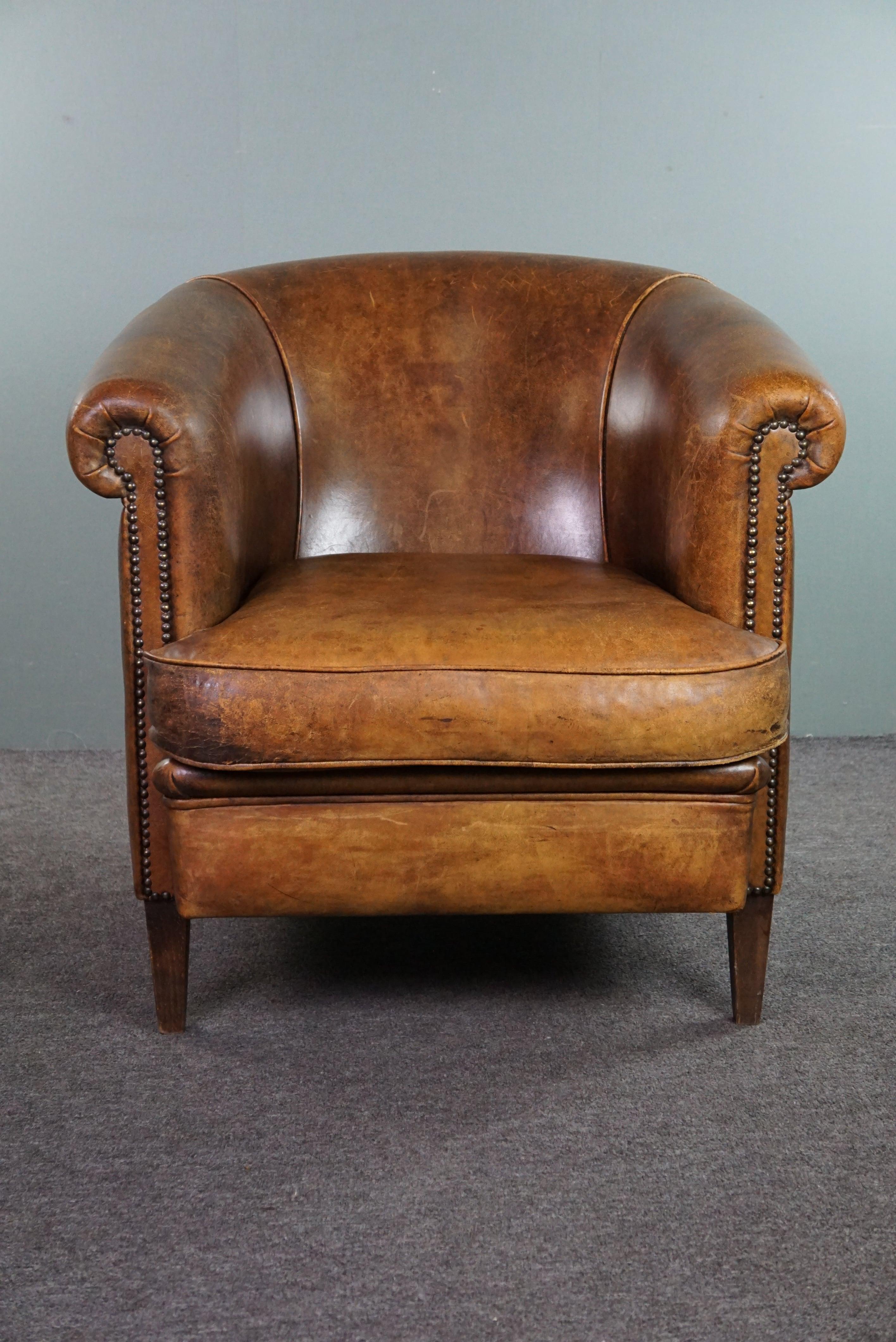 Offered is this rugged and inviting club armchair made of sheep leather finished with decorative nails.

This club armchair is one that will invite you and your guests to come and sit. You'll experience the comfort when seated, and it's a sight to