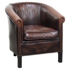 Club chair in a dark color made of cowhide leather