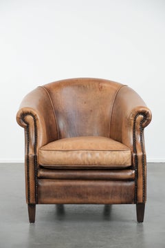 Club chair made of sheepskin leather finished with decorative nails