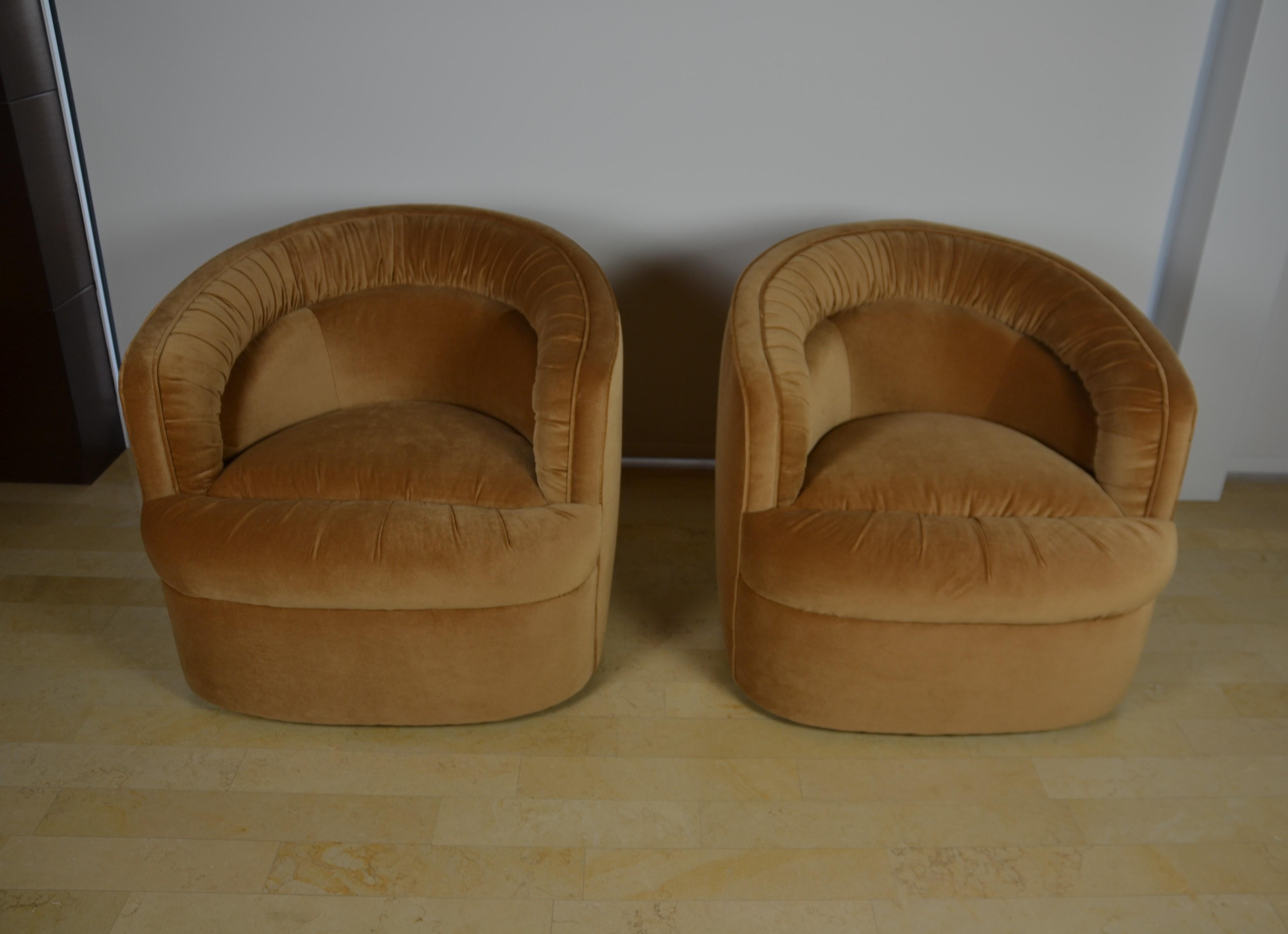 Pair of club chairs by Selig Monroe. The club chairs are in excellent condition, newly upholstered in Italian velvet fabric. The club chairs are standing on four brass casters. 