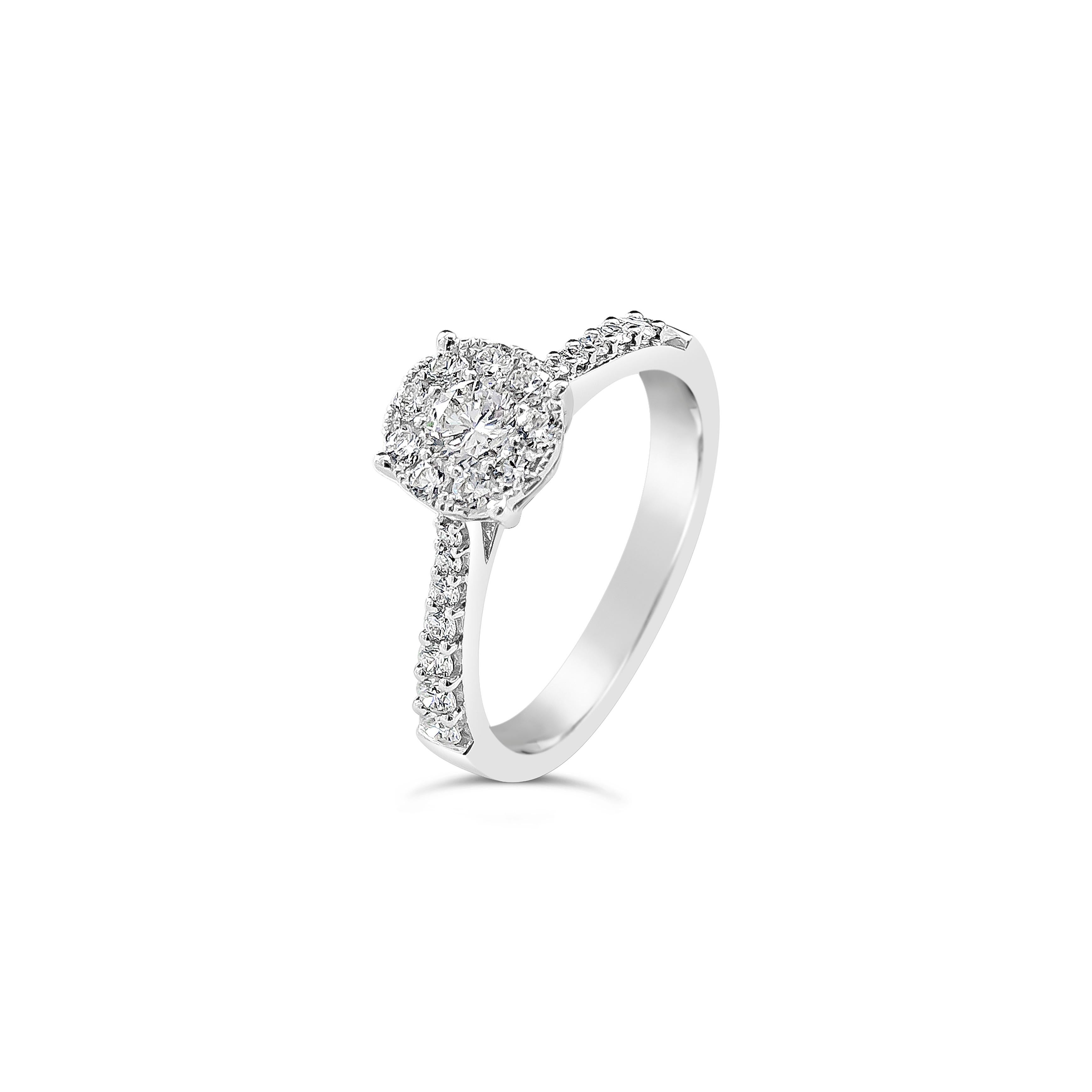 Features a center stone weighing 0.26 carats surrounded by a cluster of round brilliant diamonds set in a seamless design, set in a tapered band accented with diamonds. Accents round diamonds weighs 0.48 carats total. Made in 18k white gold, size