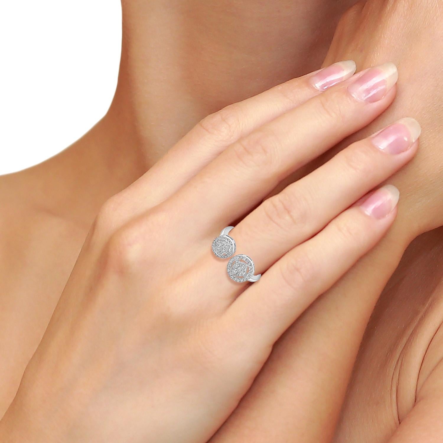 Este exclusivo anillo entre los dedos presenta un racimo de diamantes redondos dispuestos para crear el aspecto de un solitario, ofreciendo el máximo brillo con un toque moderno. Fabricada en oro blanco de 18 quilates, su diseño abierto aporta un