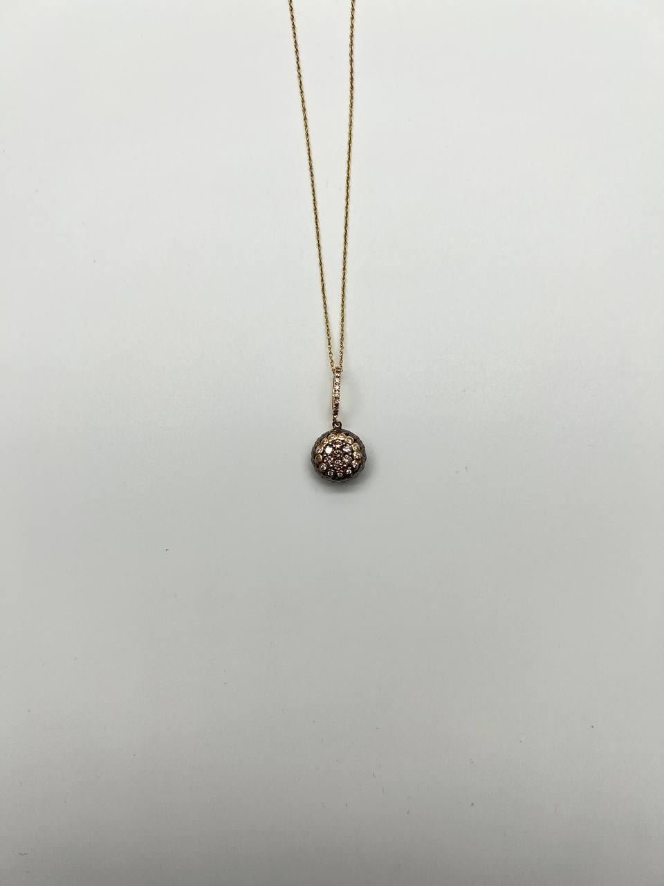 Questa elegante collana con ciondolo è caratterizzata da una catena delicata che sospende con grazia una goccia sferica incrostata di diamanti scintillanti. Il design intricato del ciondolo cattura la luce in modo meraviglioso, creando uno
