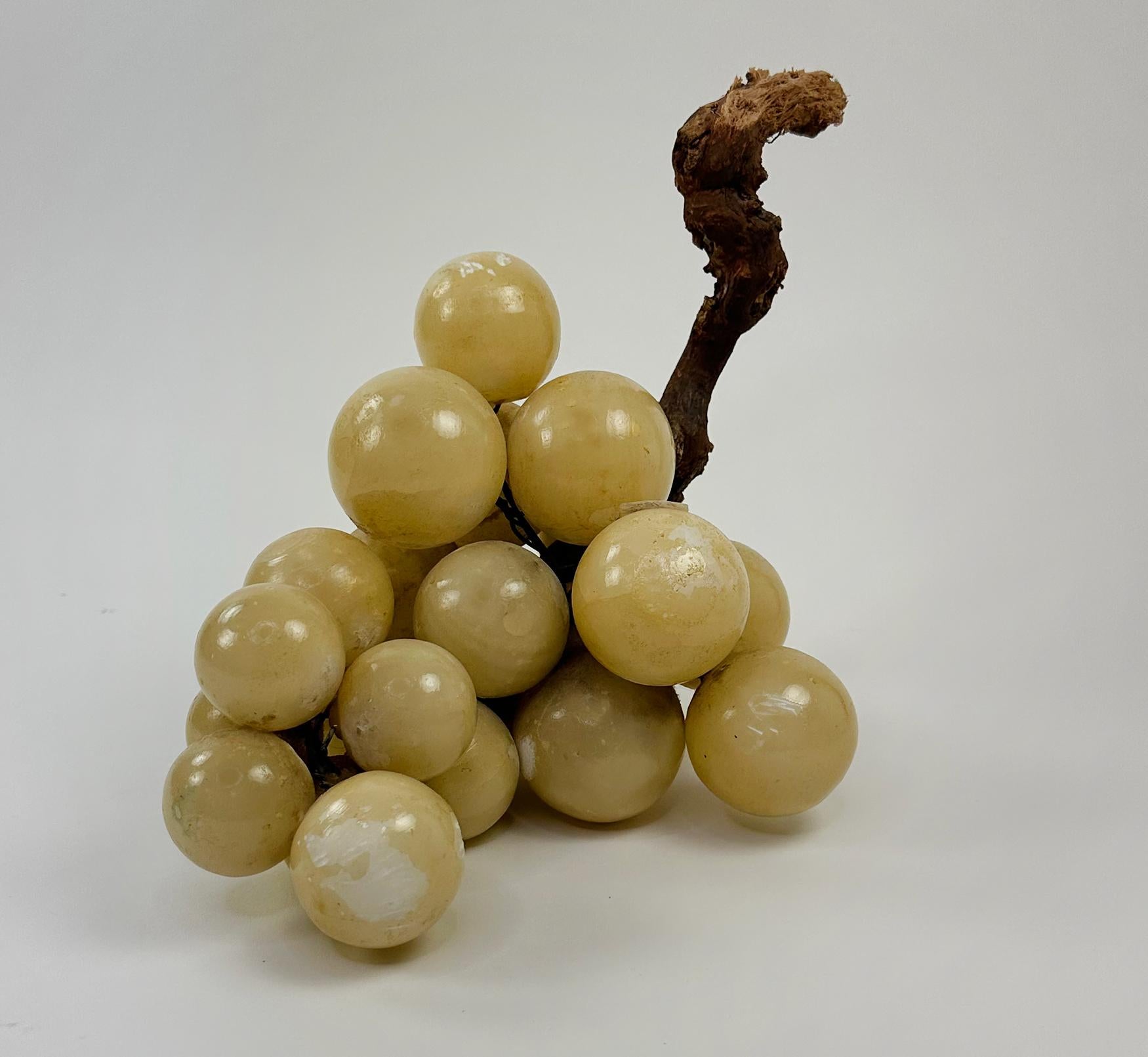 A handsome cluster of large-scale mid-century Italian grapes made in alabaster with a stem of genuine grape vine. Alabaster’s naturally shady color gives the grapes dimension and impact. Custom made and wired together by hand. This piece has scale