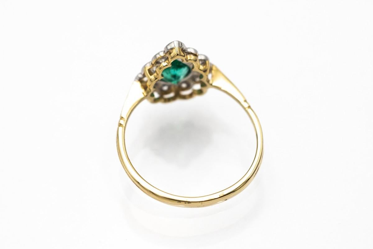 Ring aus 18 Karat Gelbgold und Platinelementen. Ring besetzt mit einem tropfenförmigen Smaragd von tiefgrüner Farbe mit einem Gewicht von ca. 0,55ct.

Ringsherum besetzt mit 11 Brillanten mit einem Gesamtgewicht von ca. 0,50ct.

Größe:  (56) -