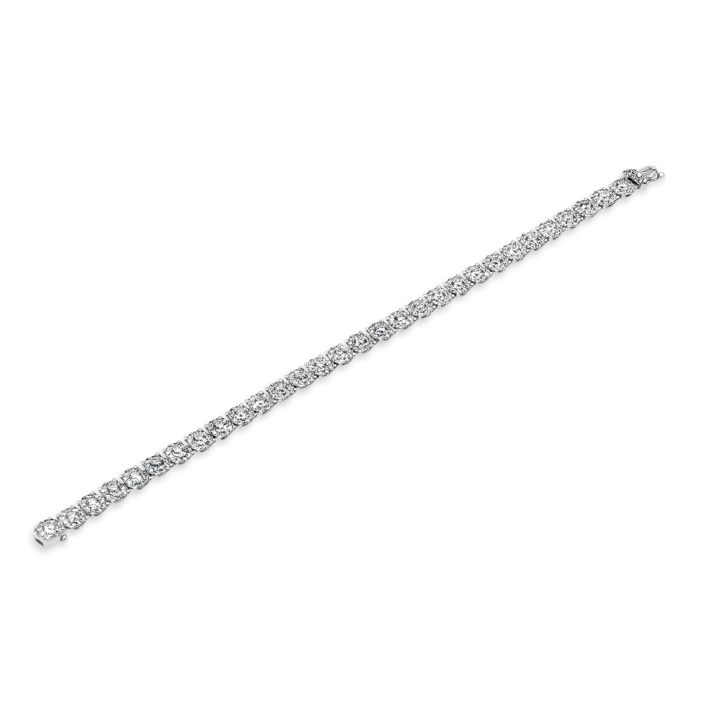 A brilliant tennis bracelet showcasing a cluster of round diamonds to give the illusion of single large diamonds. Diamonds weigh 5.86 carats total. Made in 18 karat white gold.

