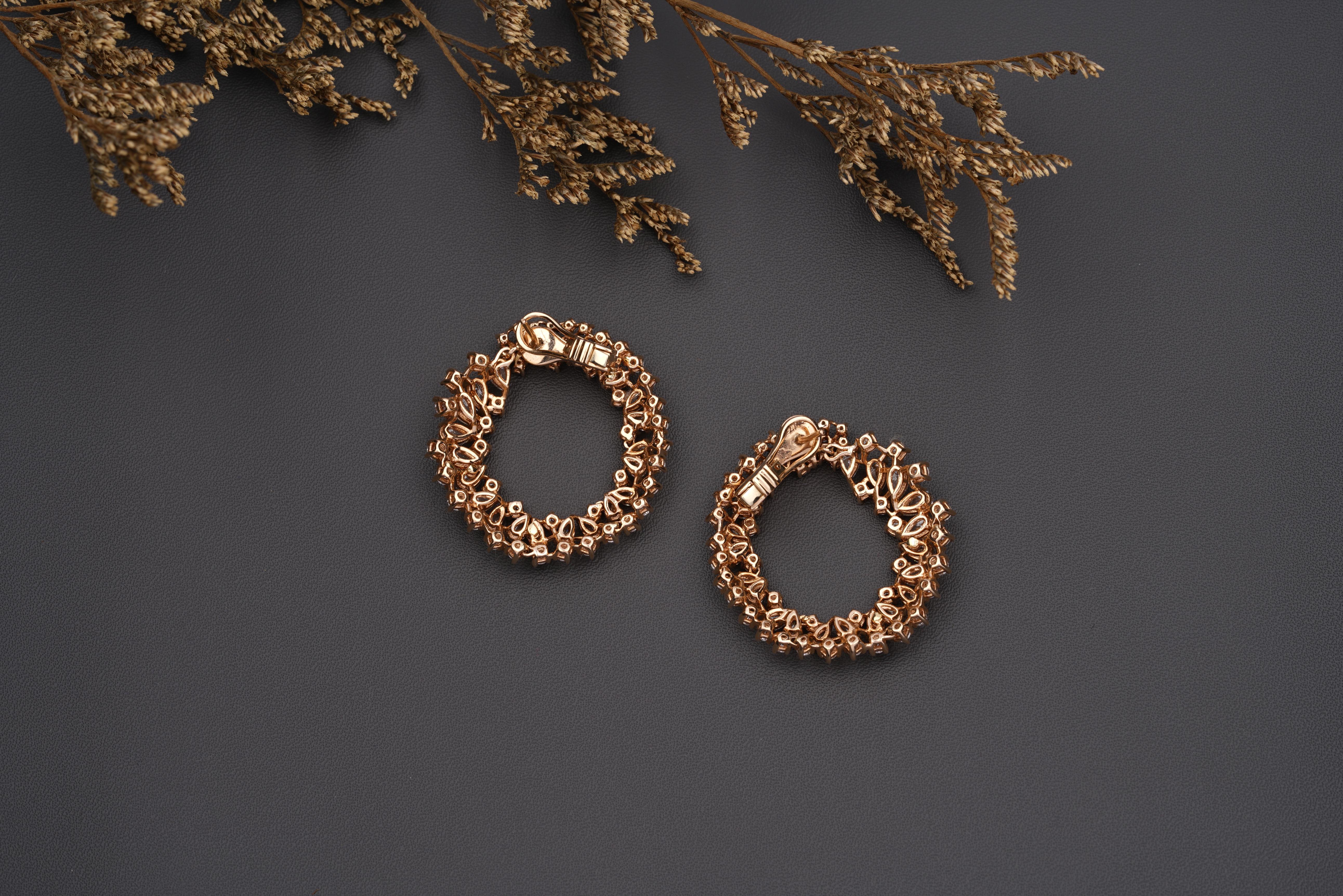 The Clustered Pear & Round Diamond Hoop Earrings are stylish and elegant pieces of jewelry made from 18K solid gold. The earrings feature a unique design with a cluster of pear-shaped and round diamonds that are set in gold hoops.

The pear-shaped