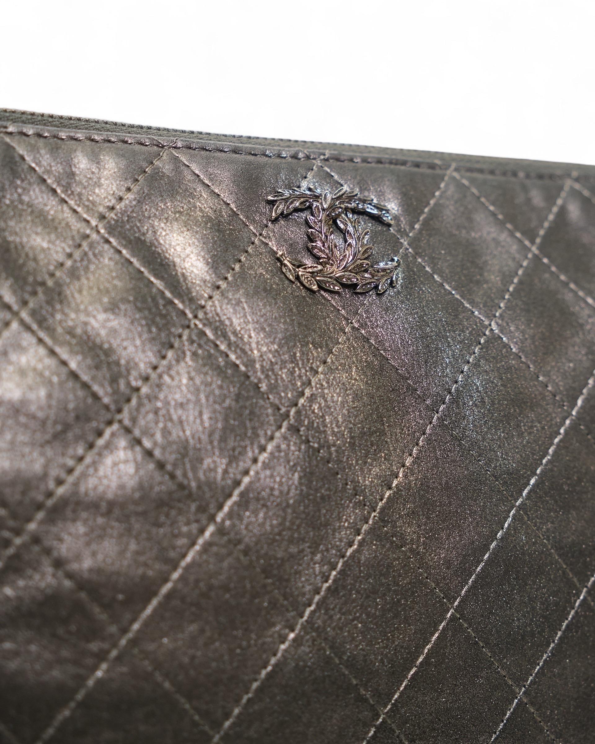 Pochette Chanel, modèle Flower, réalisée en PELLE de couleur gris satiné et ornée de ferrures argentées. Doté d'une fermeture supérieure à glissière, il est revêtu intérieurement d'un tessuto trapuntato grigio, très résistant. Année de production