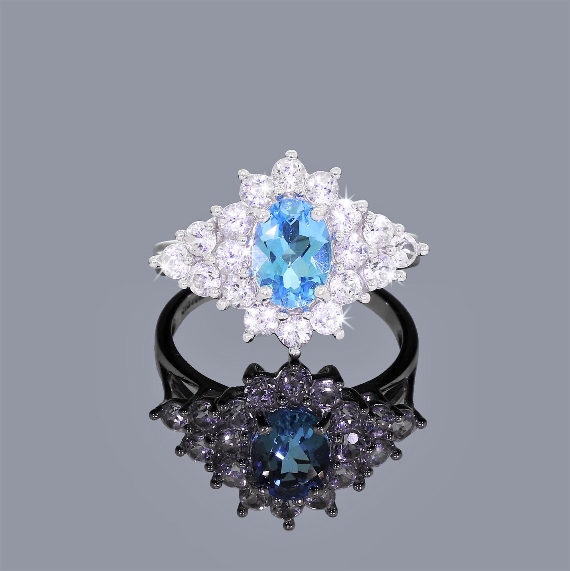 Bold and stylish 10K white gold cocktail ring completely covered in brilliant gemstones. Showcases a large, faceted oval-cut blue spinel surrounded by a cluster of 18 glimmering white sapphires. 

The face of this ring is extremely ornate and eye