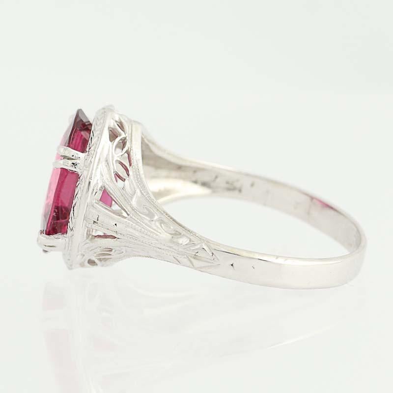 Art Deco-inspired! Designed by Clyde Duneier in 14k white gold, this gorgeous Art Deco-style ring features a genuine rubellite. The oval-cut gemstone is ported from underneath to accentuate its rose-red sparkle and framed in wheat-chain detailing. A