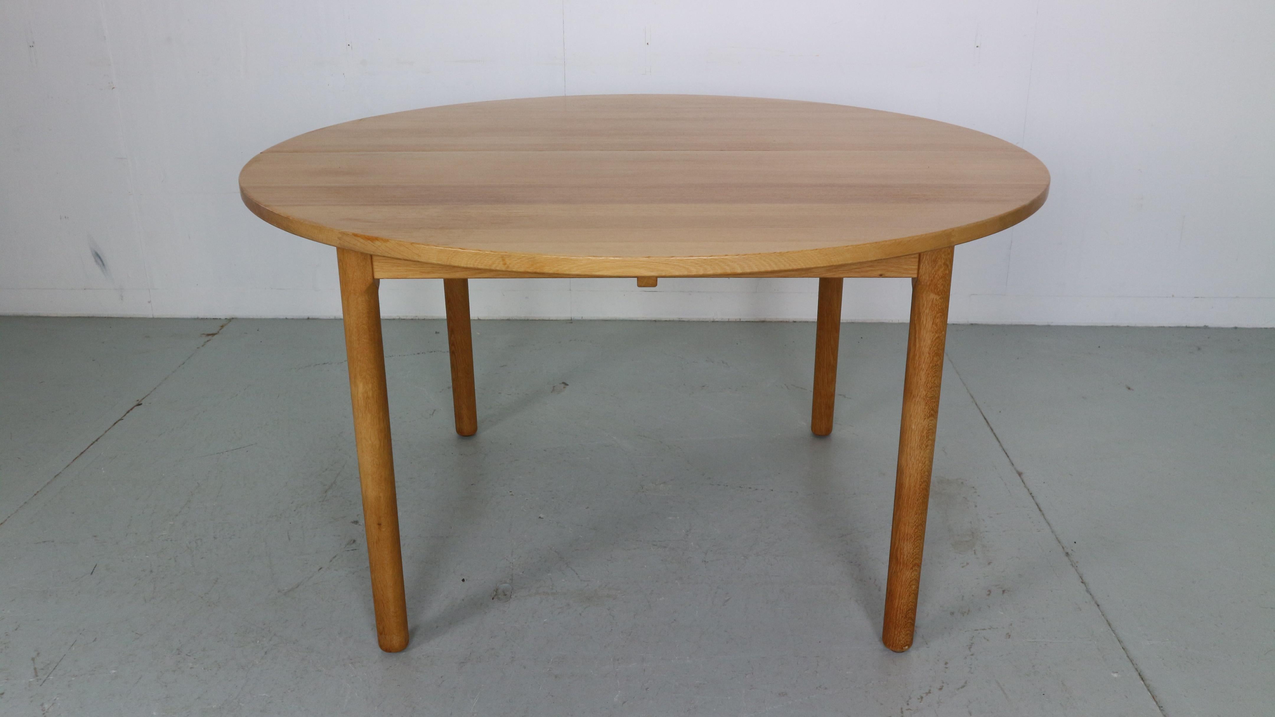 Scandinavian modern period dining table designed by hans J. Wegner and manufactured for CM-HAARBY in 1970s period, Denmark. 
Made of oak wood. 
Round dinning table has an extension leave. Extended from 129cm to 179cm wide. 
The table is in a great