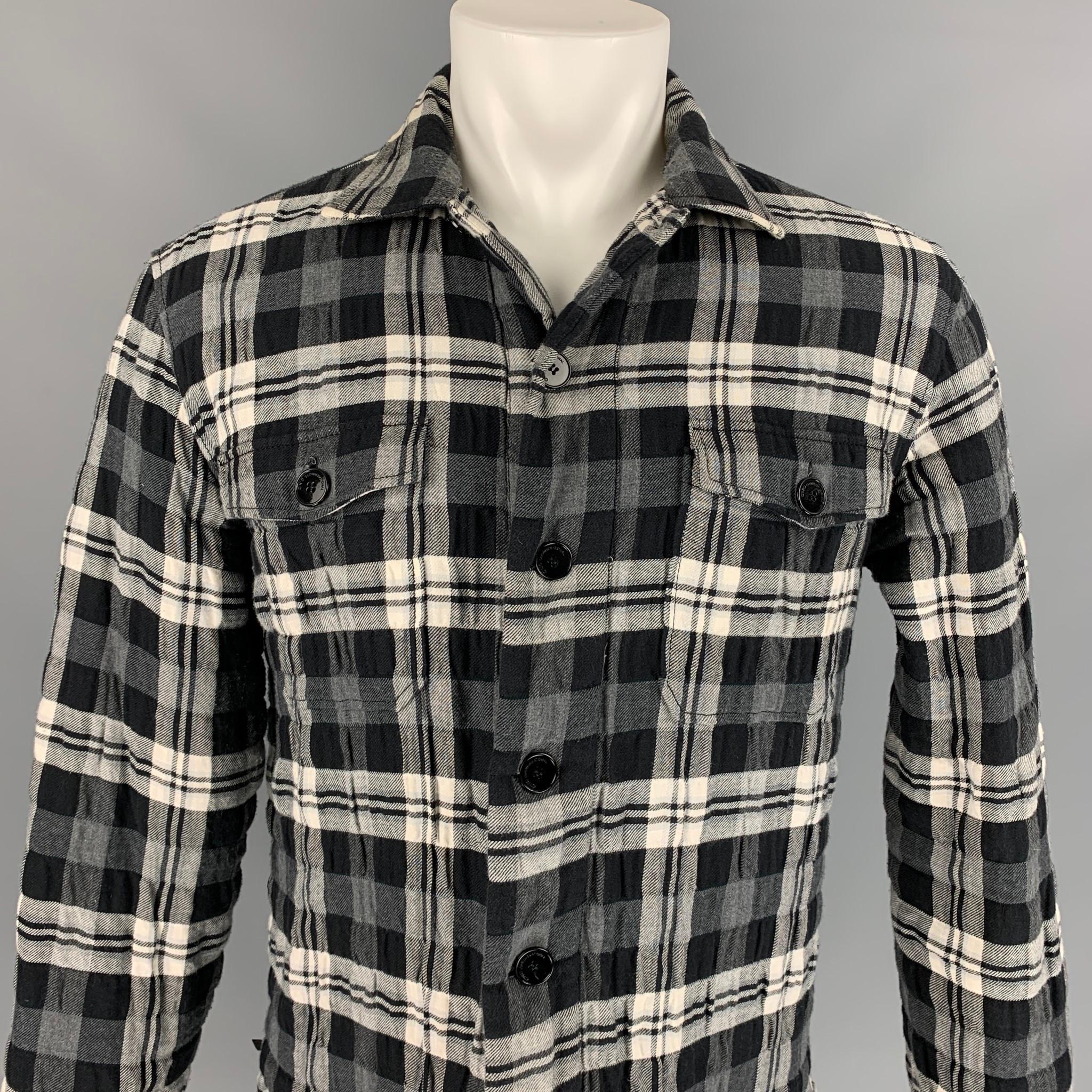 C'N'C by CoSTUME NATIONAL shirt jacket comes in a black & white plaid polyester / cotton with a quilted liner featuring a spread collar, adjustable side tabs, front pockets, and a buttoned closure. Made in Italy. 

Very Good Pre-Owned