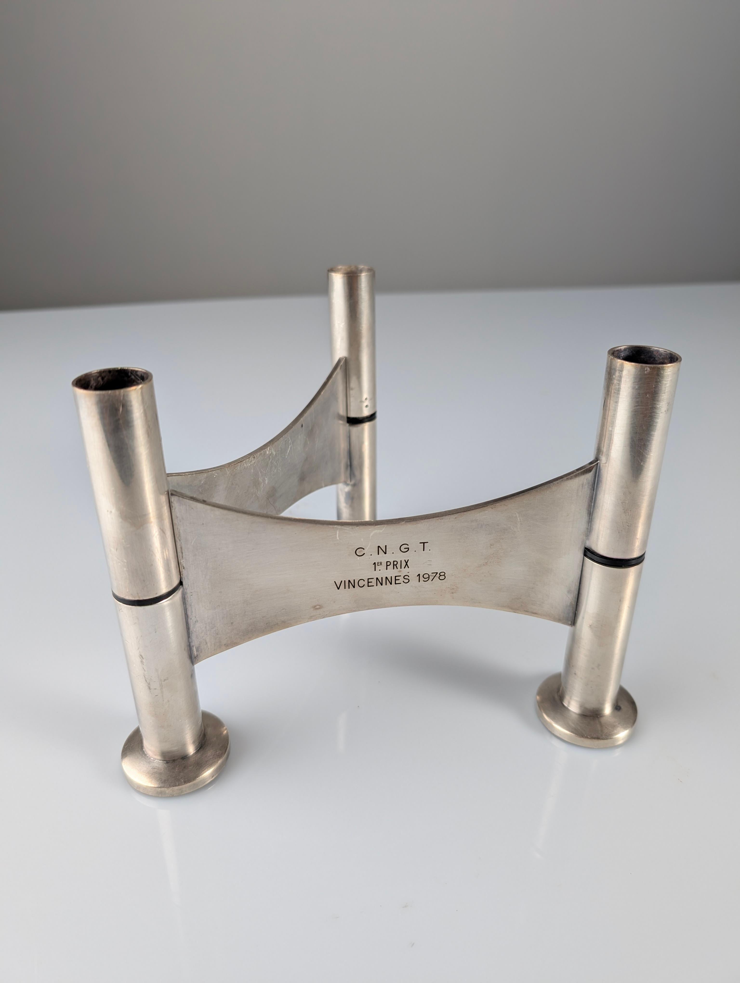 Questo candeliere o centrotavola altamente scultoreo e modernista, attribuito al celebre designer francese Roger Tallon per il prestigioso argentiere Ravinet d'Enfert, è un pezzo notevole di storia e design. La sua provenienza è eccezionale: