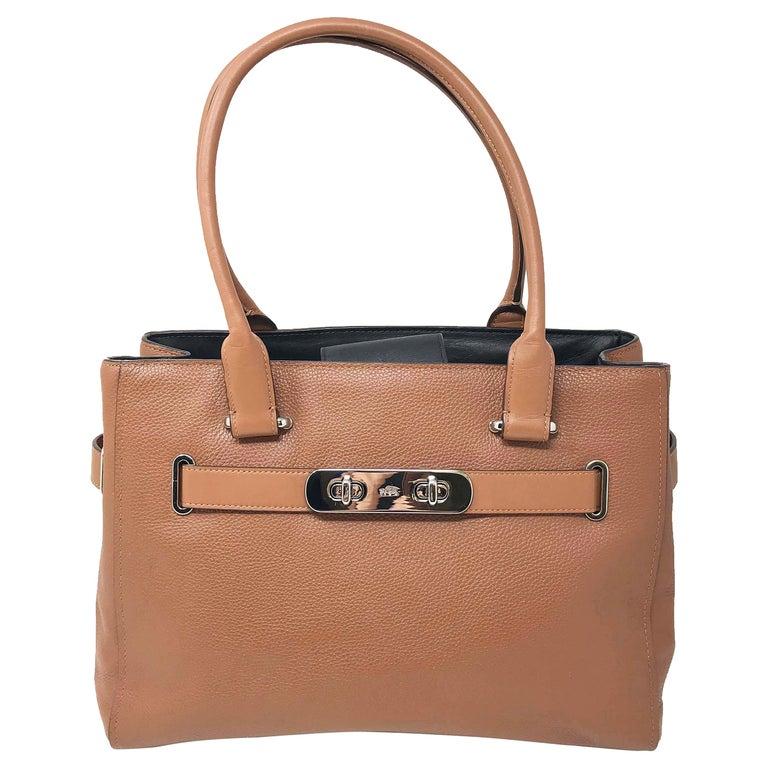 Coach Swagger Ladies Leather Carryall Handbag 34408. Product Dimensions: 9in (H) x 12.75in (L) x 6in (W). Features a top zip closure, an interior zip pocket, interior slip multifunction pockets, and a removable strap. Silver tone hardware. Large
